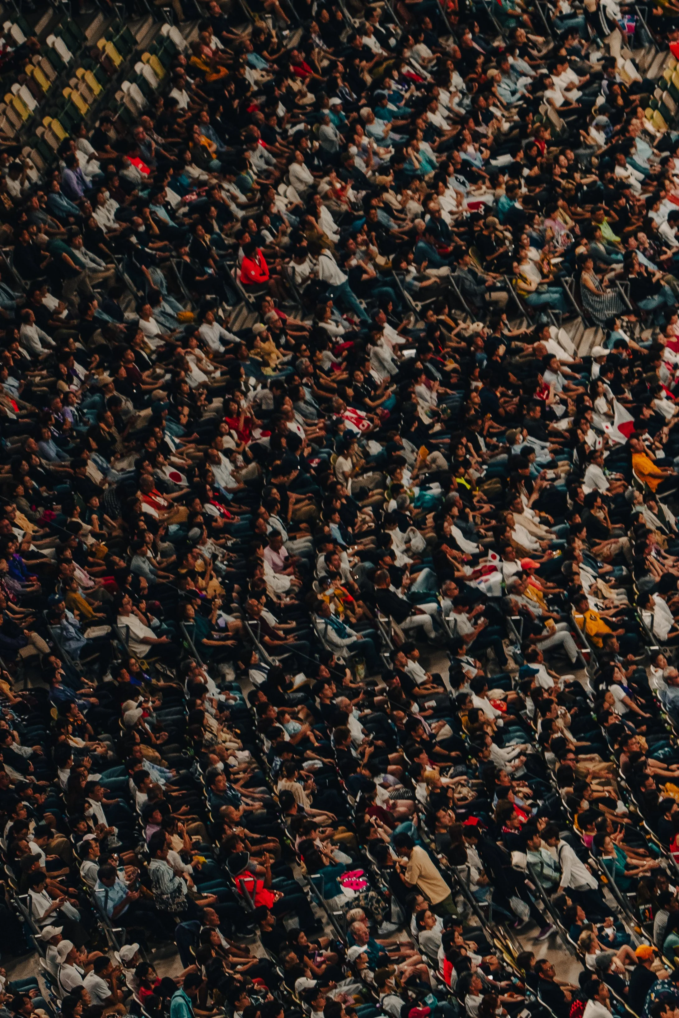 A large crowd of people seated in an auditorium or conference hall, attending an event or presentation.