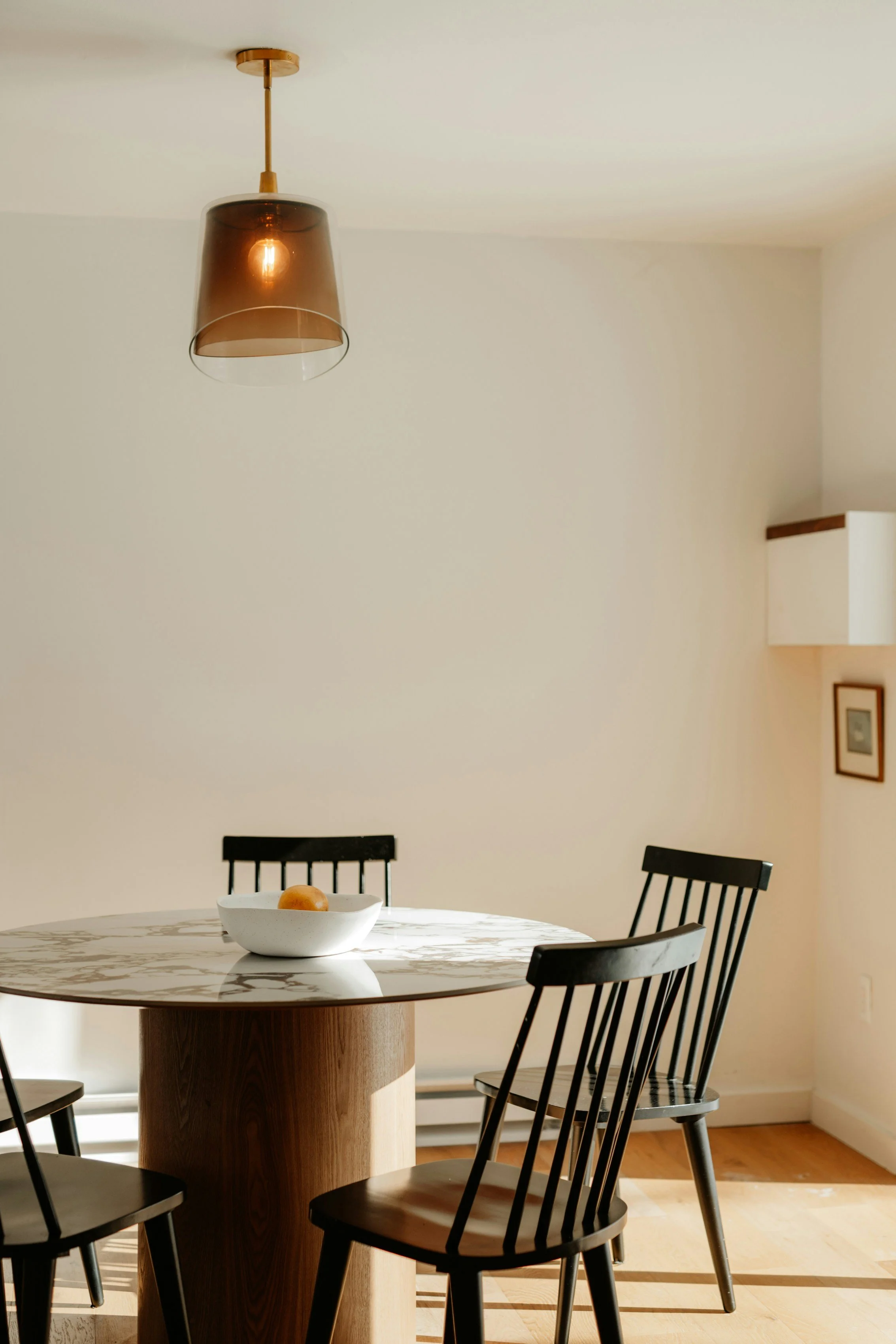 Clean dining room with round table and pendant light