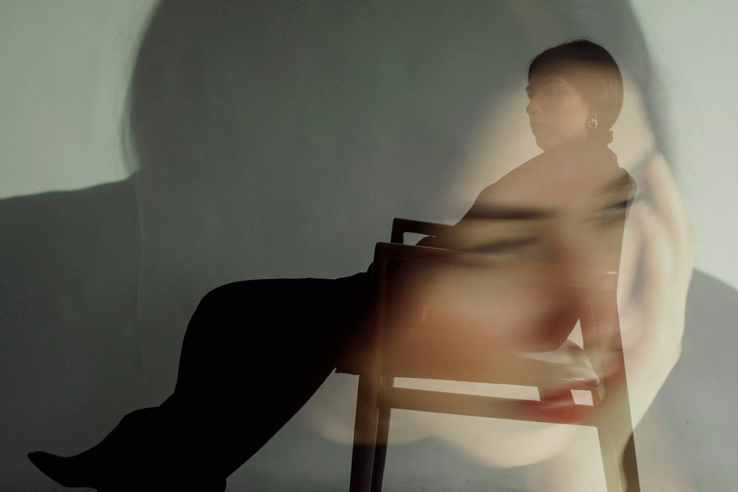 Double exposure photo of a person in a chair and another with their head in their hand