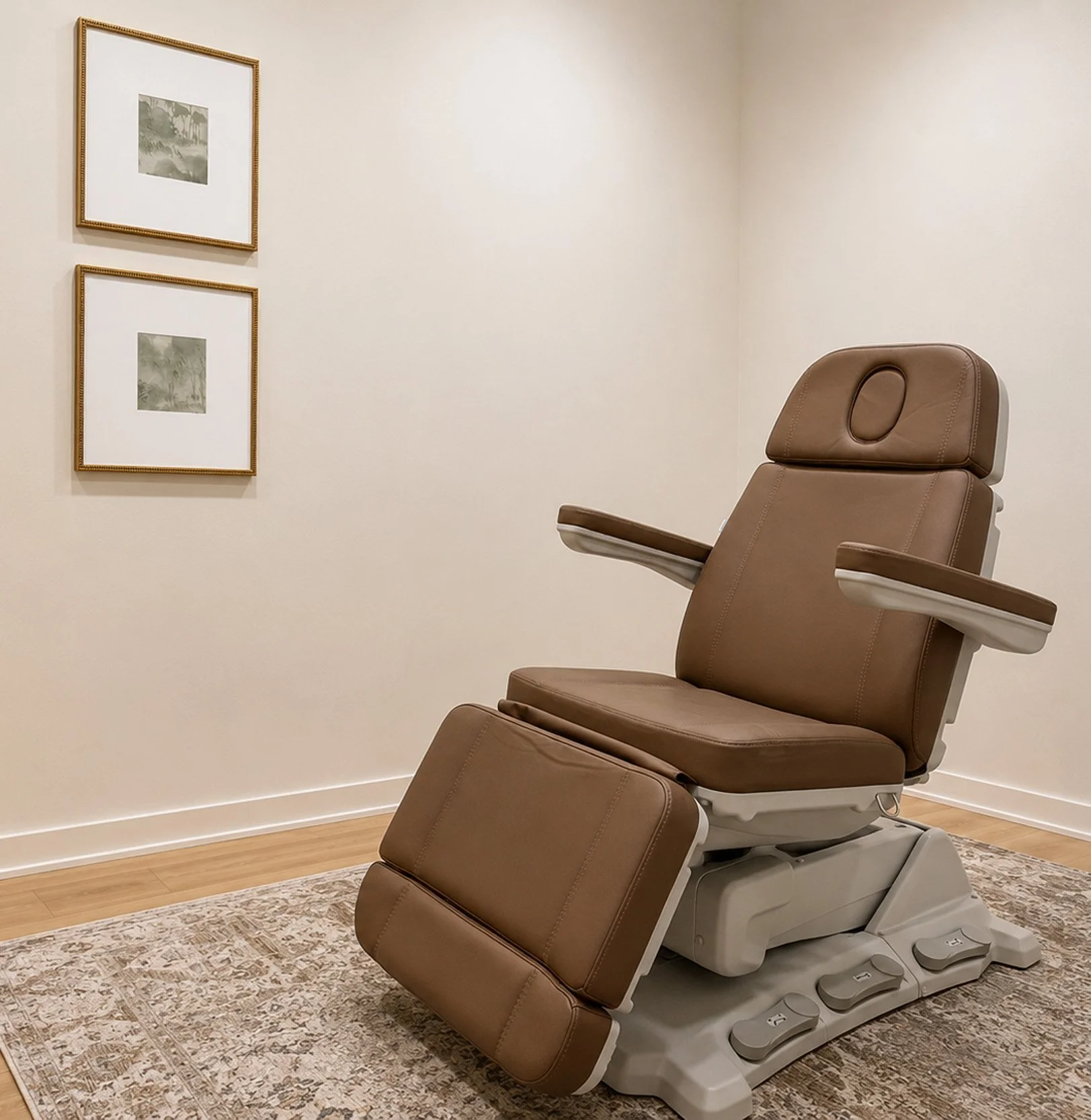 A medical examination room with a beige reclining chair and three framed black-and-white pictures on a cream-colored wall.