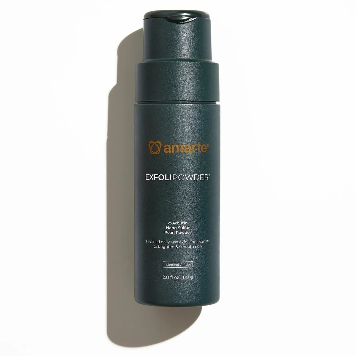 A dark gray cylindrical bottle of Amarte ExfoliPowder with orange and white text on it, standing upright on a white surface.
