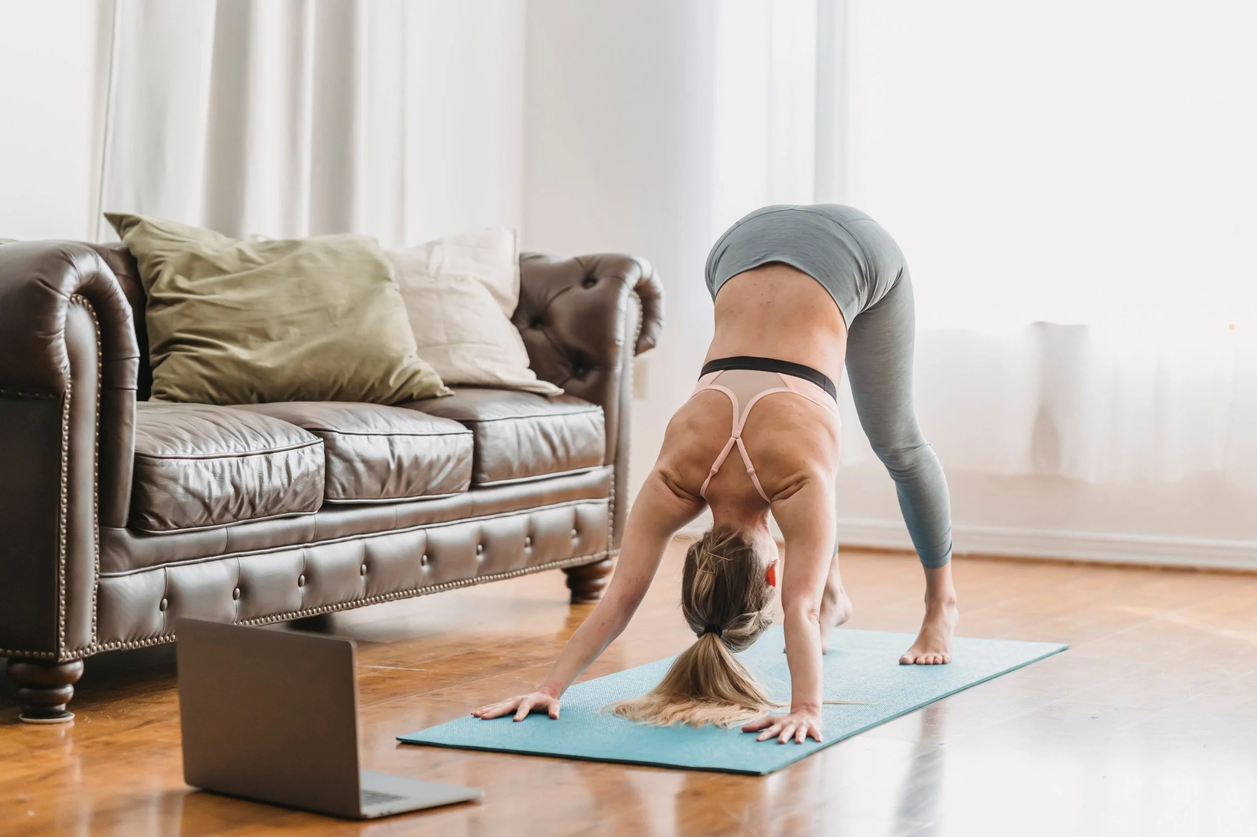 photo of a woman doing yoga in front of her laptop