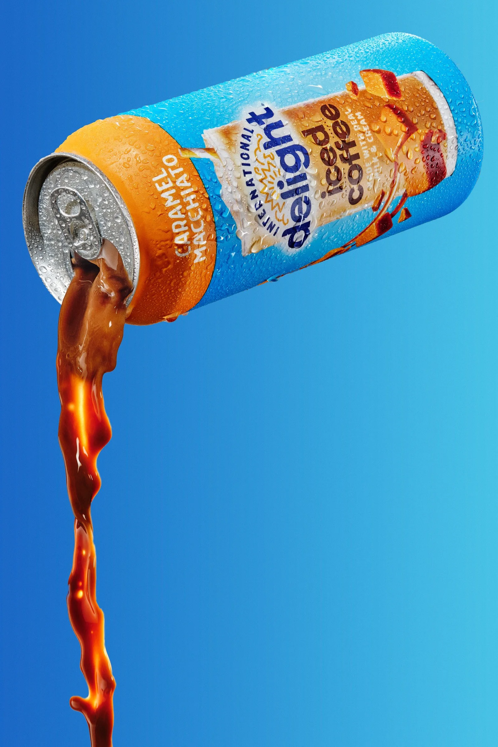 Can of Del Monte Caramel Macchiato coffee drink with caramel spilling out of the open tab against a blue background.