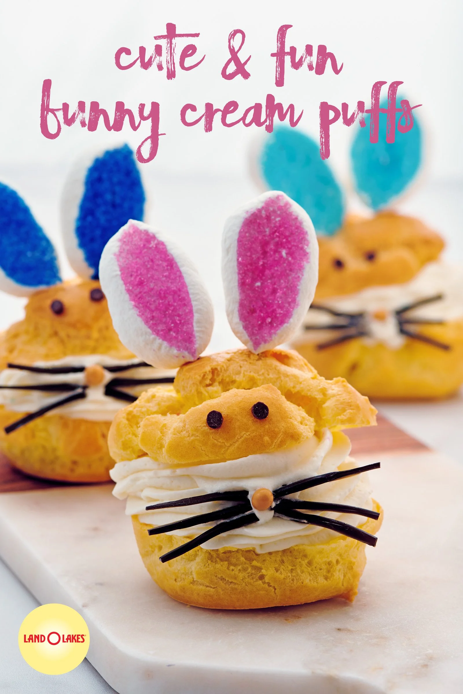 Miniature bunny-shaped cream puffs decorated with colorful sugar-rolled marshmallows for ears and small chocolate pieces for eyes, assembled as an adorable bunny dessert.