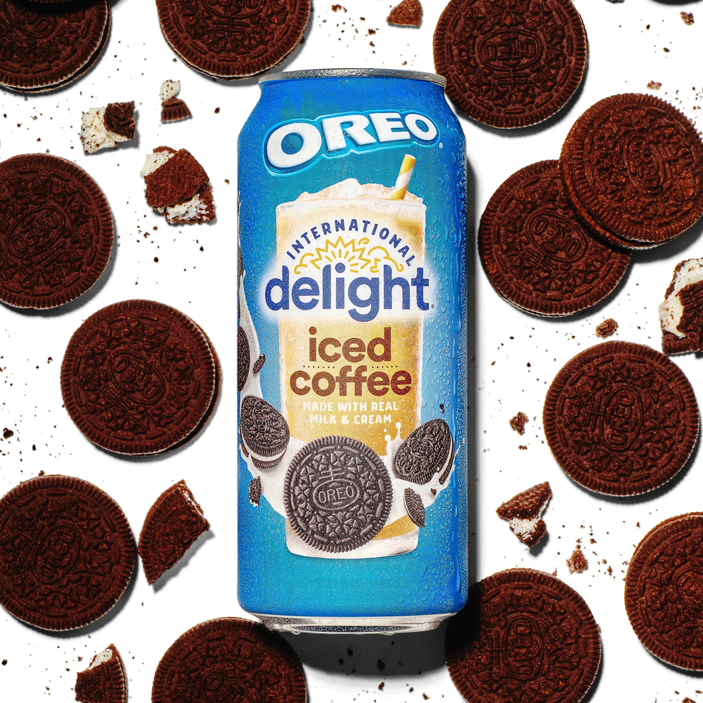 A can of Oreo Iced Coffee surrounded by Oreo cookies and cookie crumbs