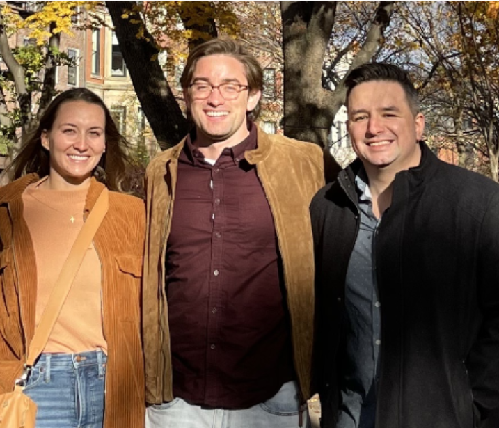 Encora Therapeutics Founders standing outdoors against autumn trees and a brick building, dressed in casual jackets and sweaters.