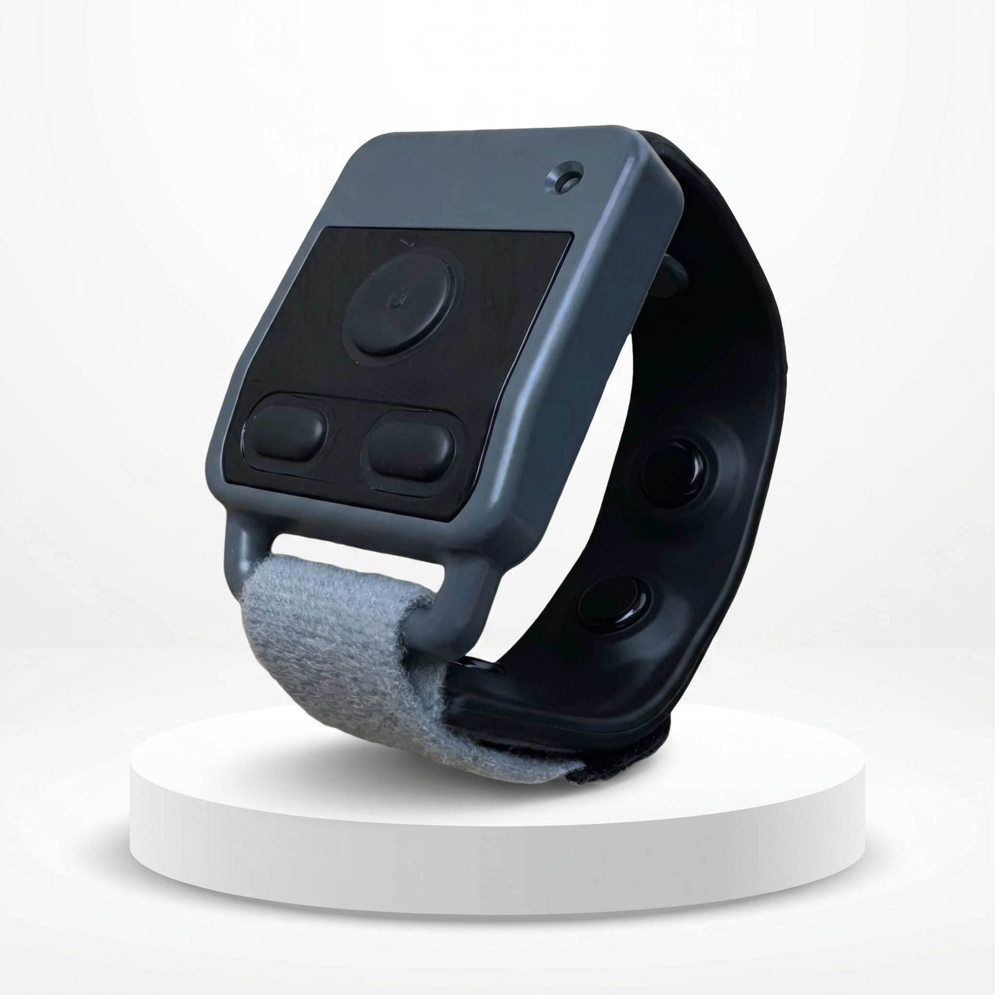 Close-up of a black and gray electronic device with buttons and a circular dial, mounted on a stand against a white background.