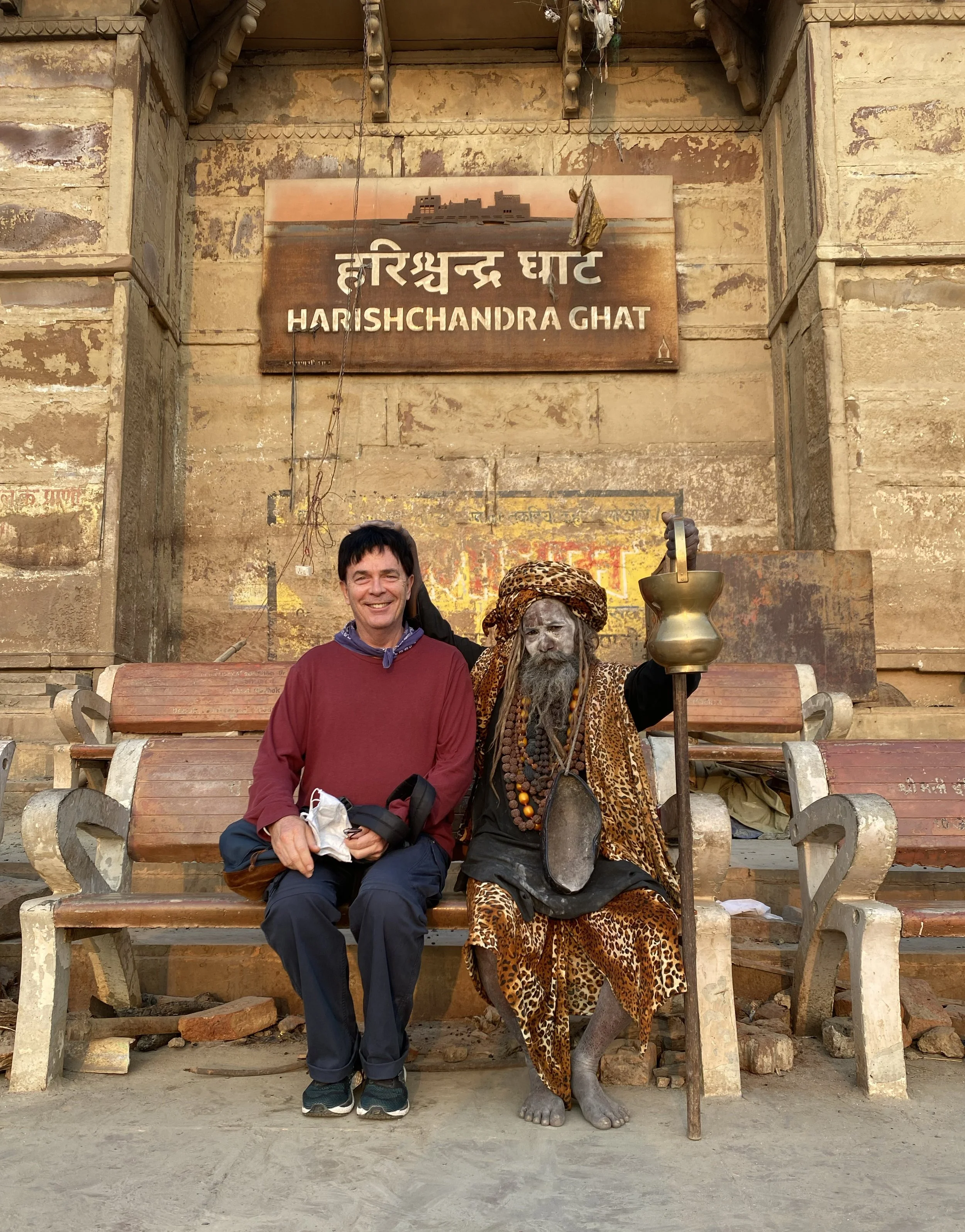 Jeff in Varanasi, India, seated with a Hindu sadhu at Harishchandra Ghat along the Ganges River.