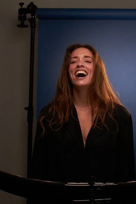 Client laughing during a behind-the-scenes personal branding photography session in the studio.