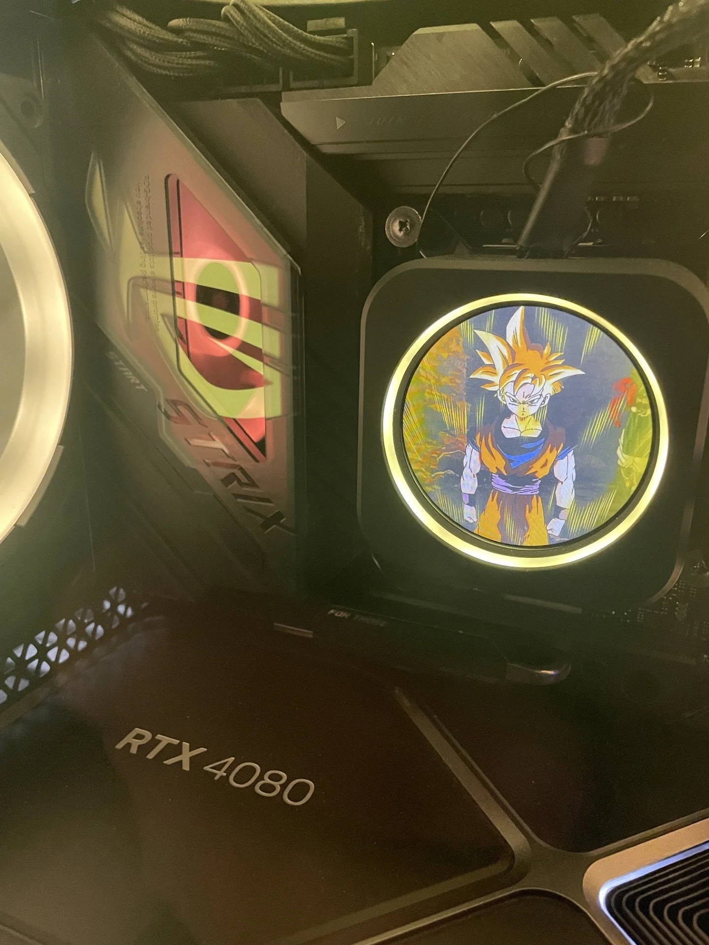 Close-up of a computer cooling case with a glowing circular display featuring Goku from Dragon Ball Z in his Super Saiyan form.