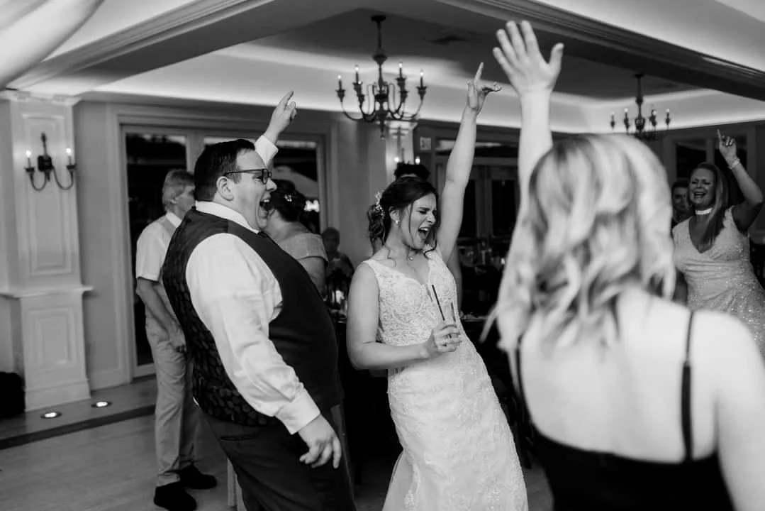 People celebrating at a wedding reception, dancing and enjoying the moment.