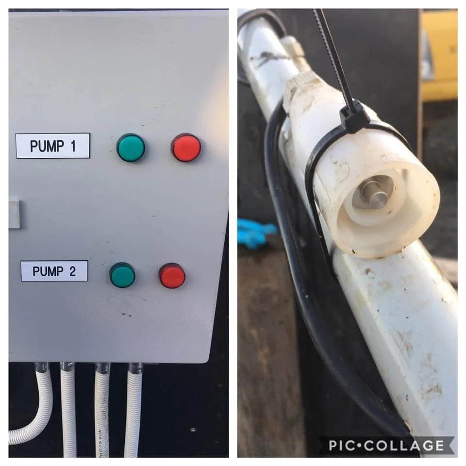 Image showing a control box with labeled buttons for Pump 1 and Pump 2, each with a green start button and a red stop button, next to a part of a white pump or pipeline with attached electrical wiring.