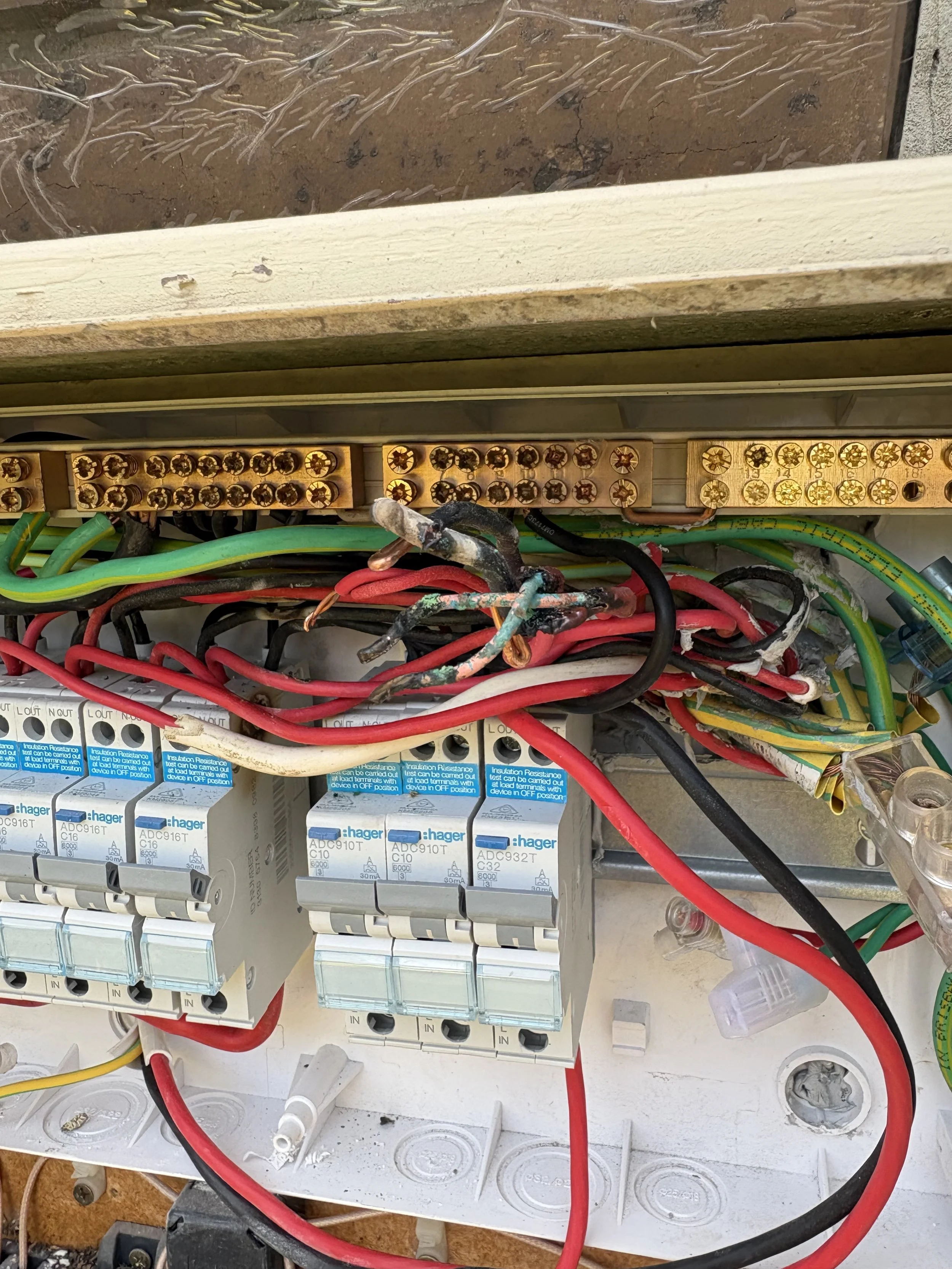 An open electrical panel showing various colorful wires, circuit breakers, and electrical components.