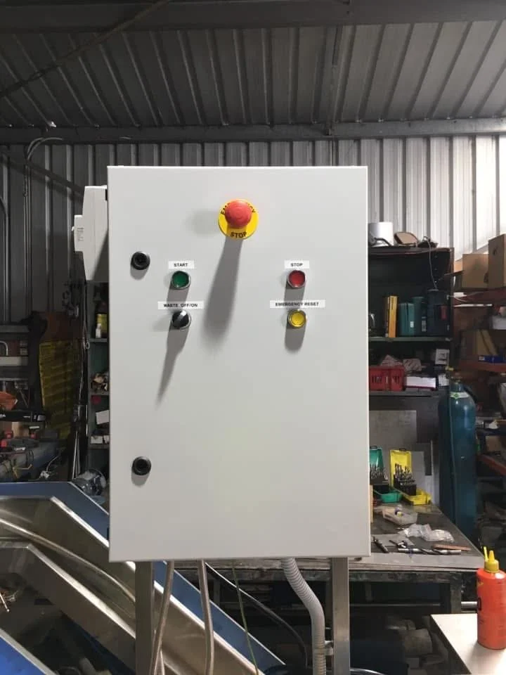 Industrial control panel with buttons and switches inside a metal shed