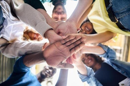 Group of diverse people joining hands together in a circle.