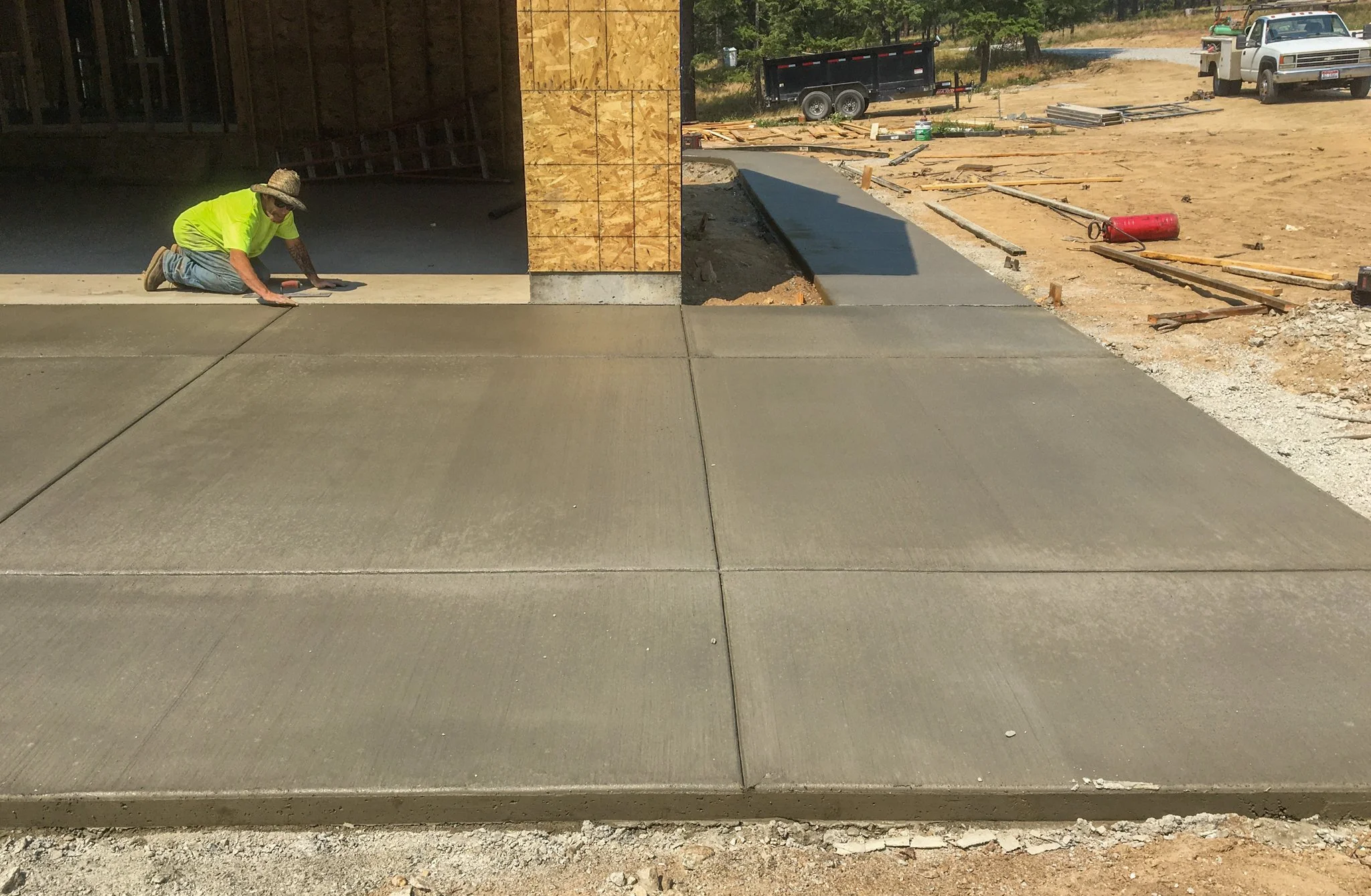 Flatwork: smoothing a newly poured concrete garage apron.