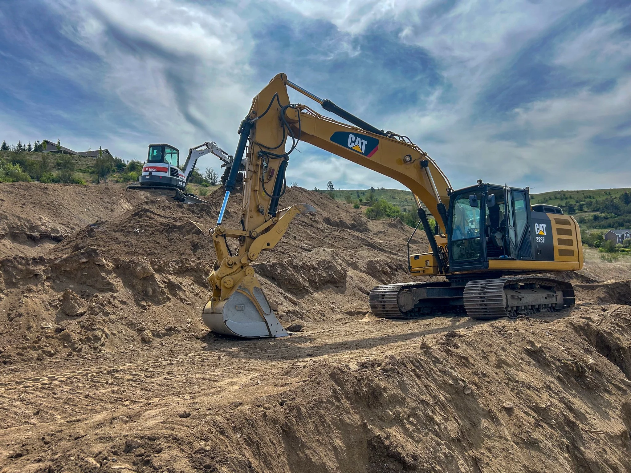 Excavating and grading a hillside foundation site for a custom home in North Idaho.