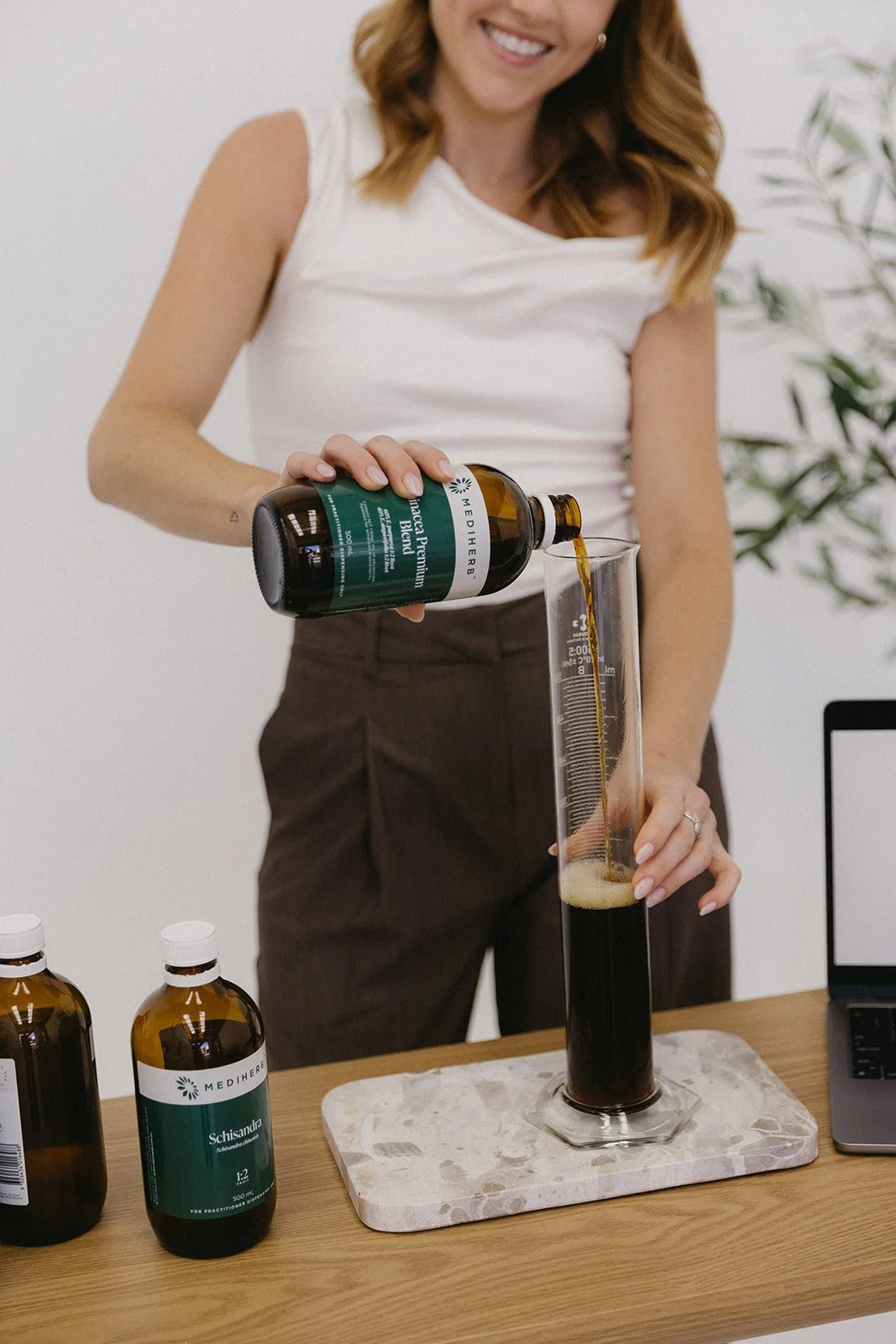 Naturopath for fertility and hormonal health preparing a herbal supplement for a client