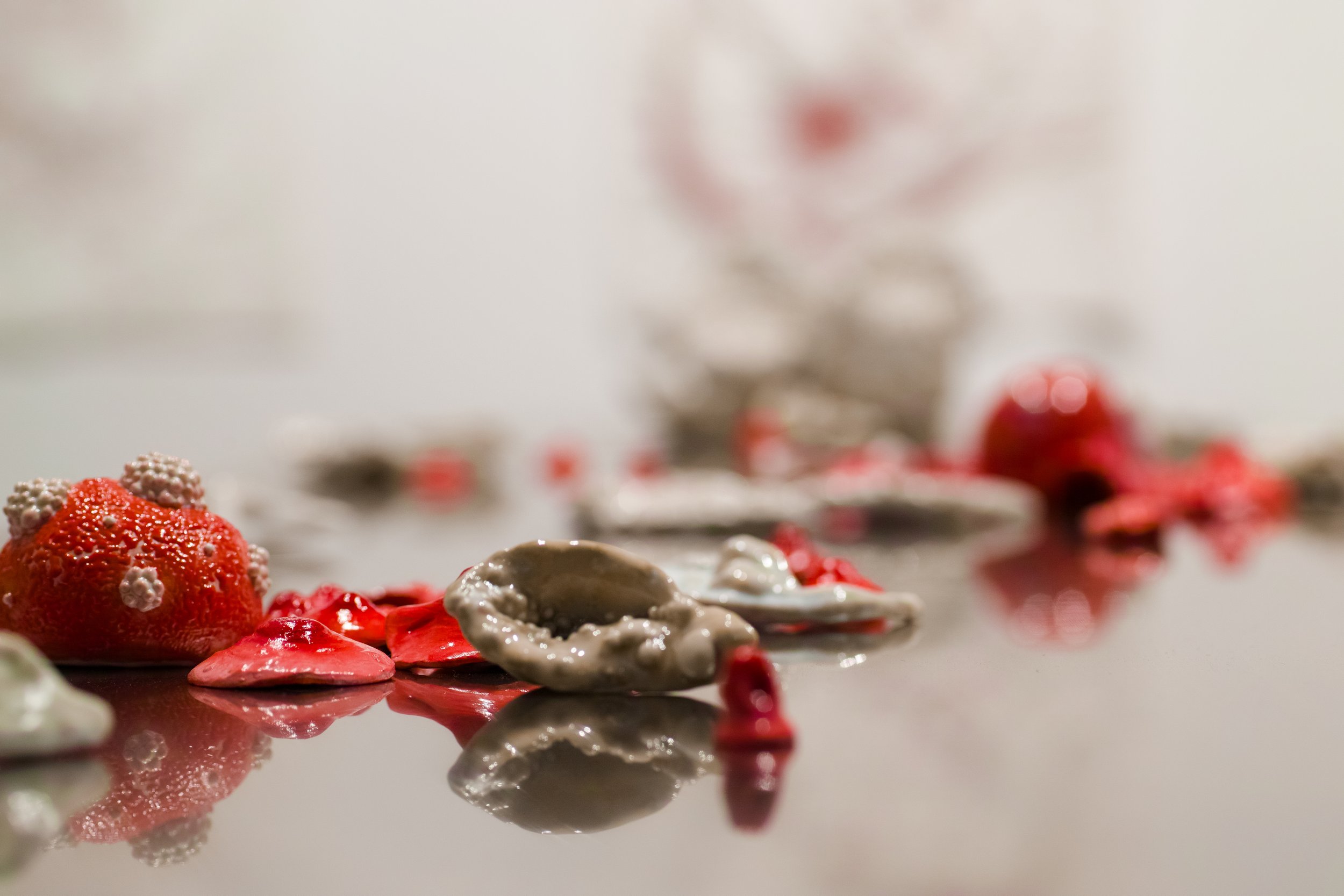 small ceramic artwork on reflective stainless steel surface