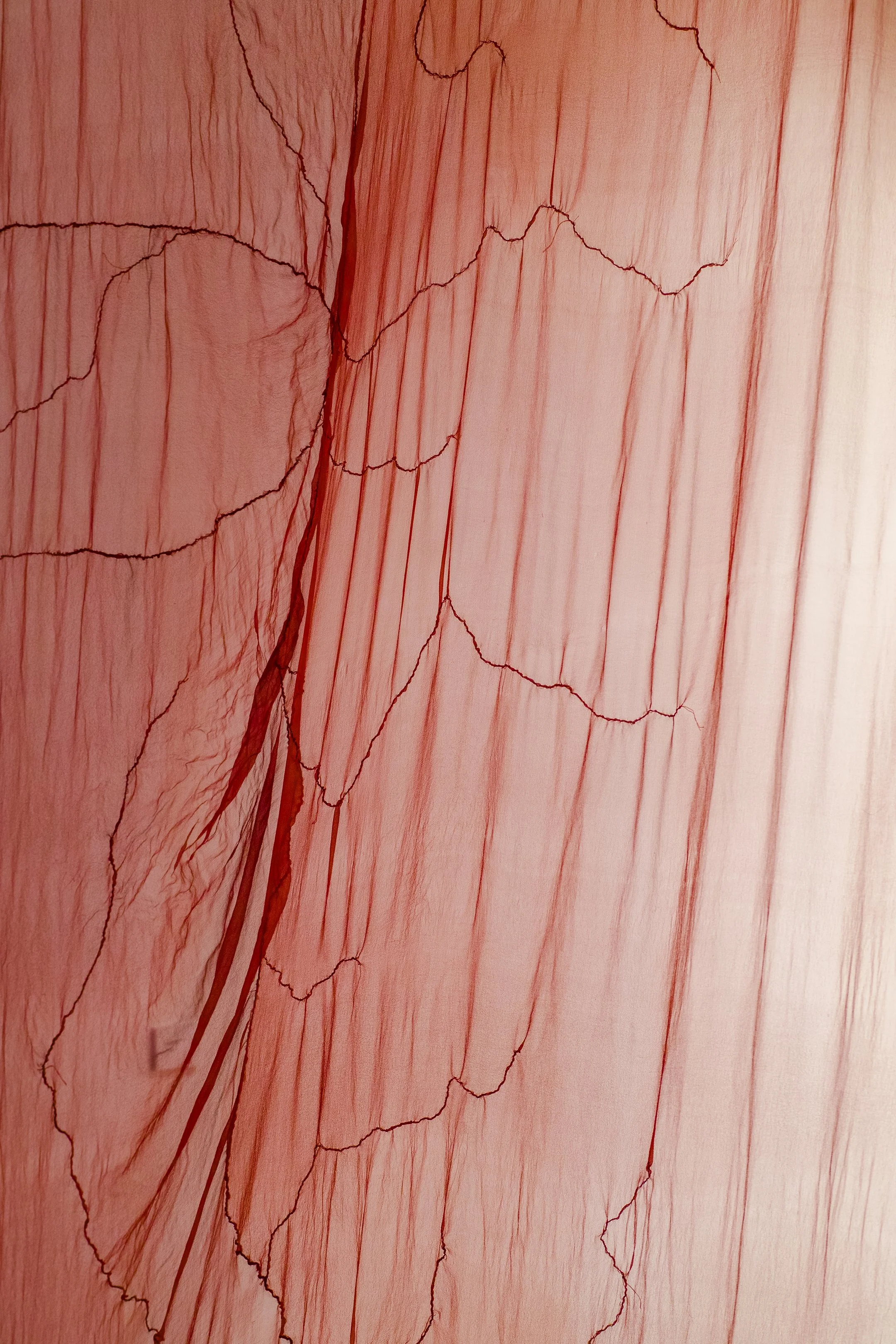 Close up of translucent red silk fabric.