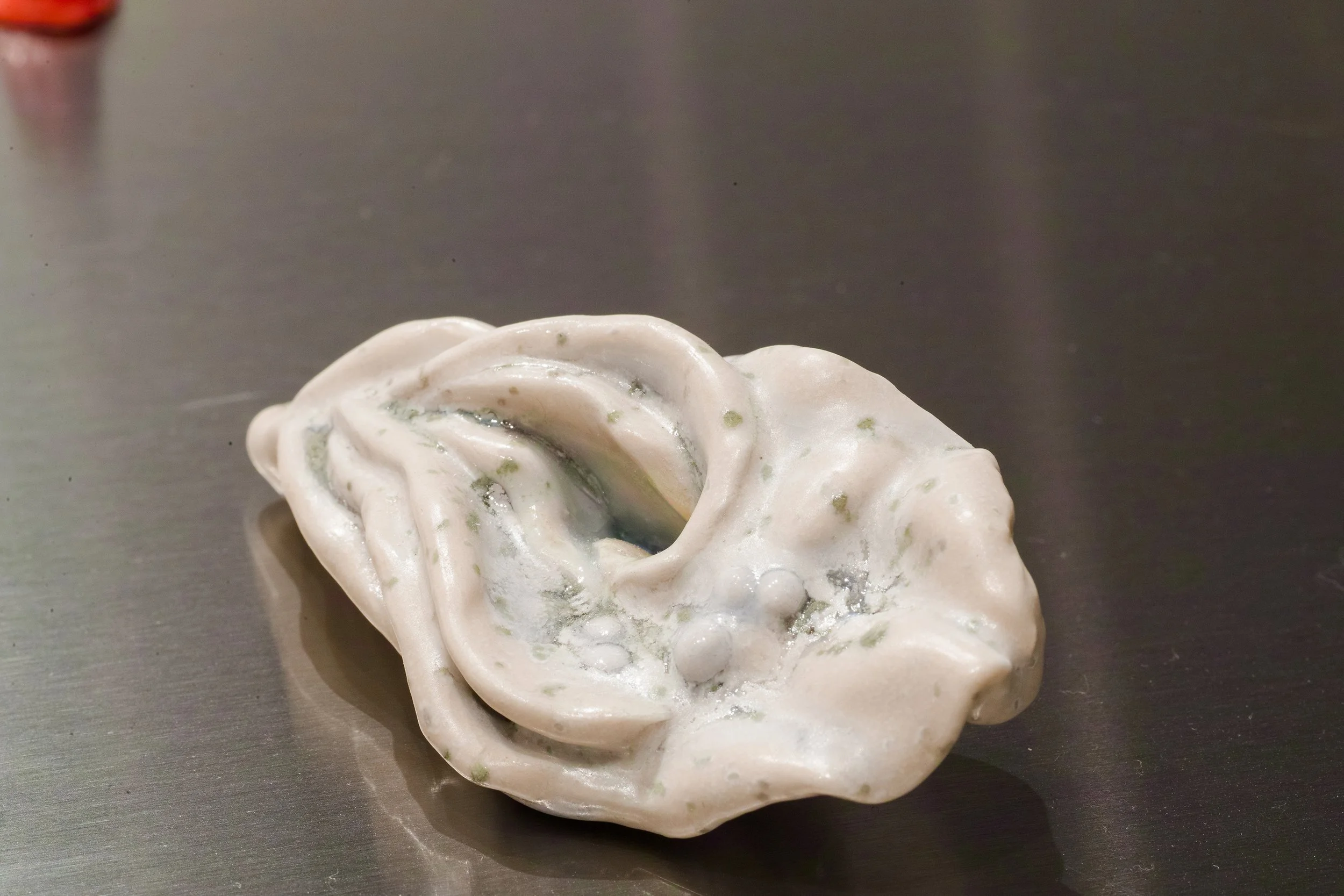 small ceramic sculpture on a reflective table