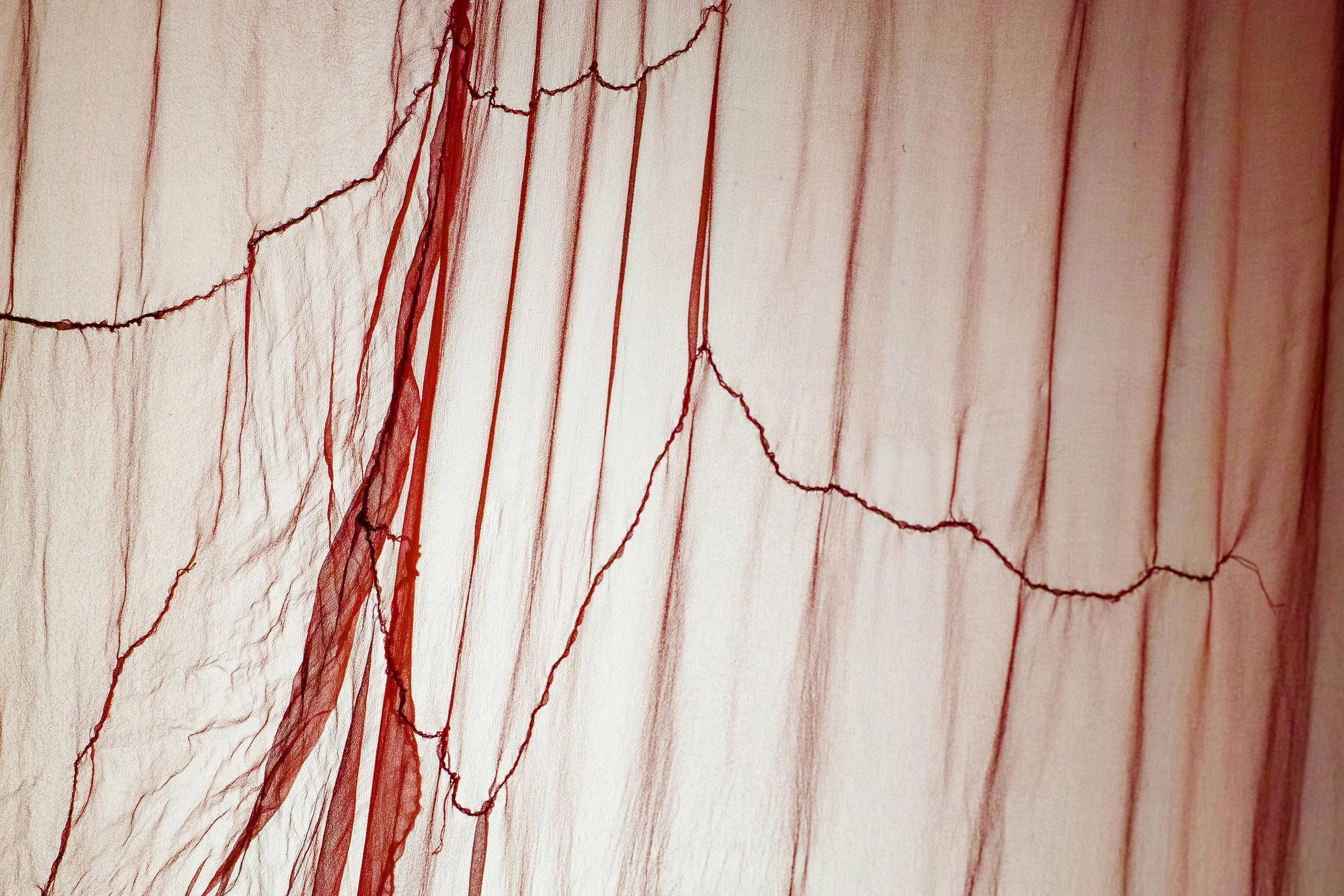 Close up of translucent red silk fabric.