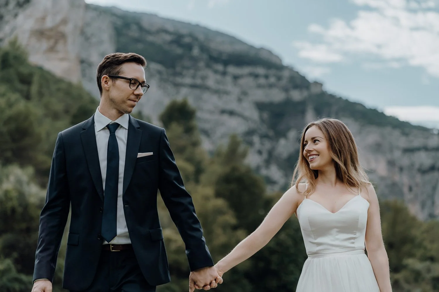 Tabitha and Greg looking at cheater holding hands with the mountain behind them