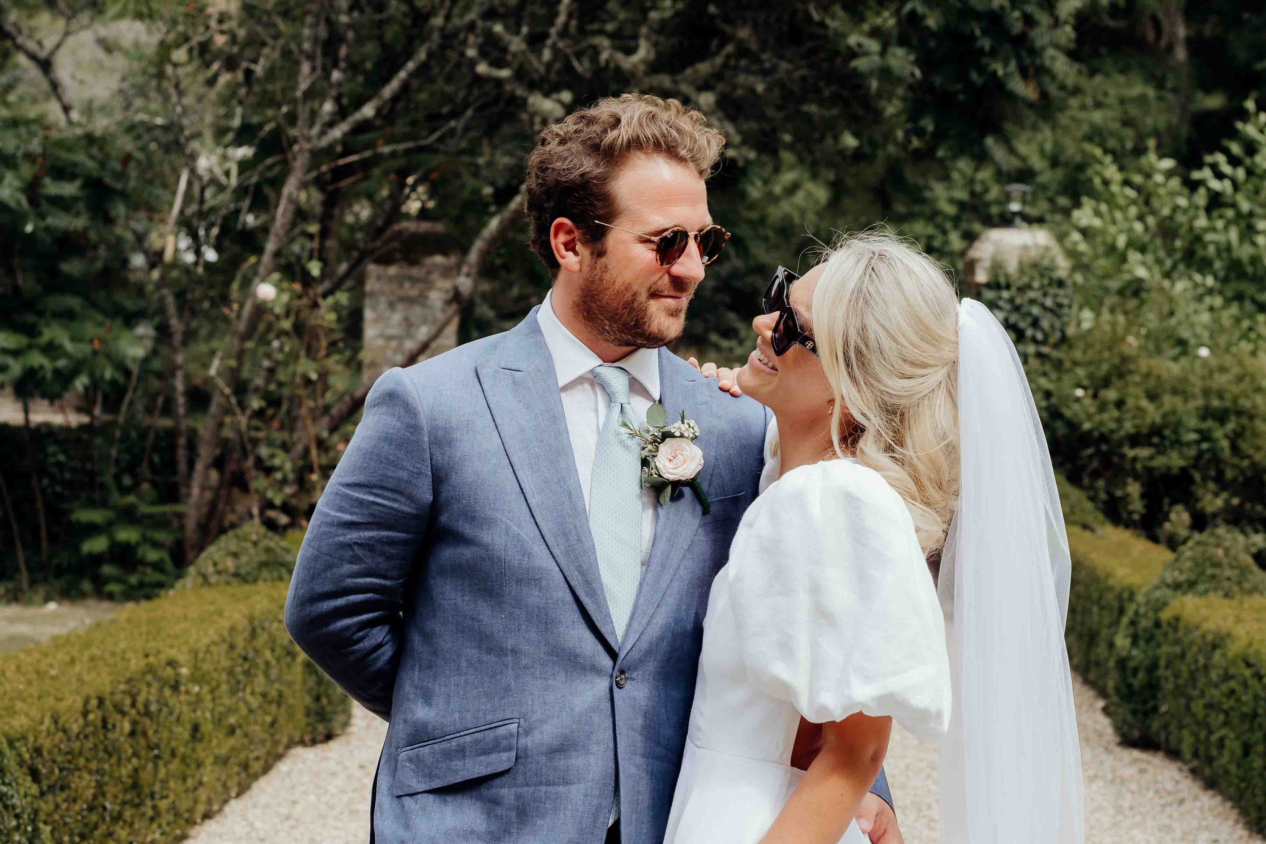 Millie & Toby staring at each other at their wedding with some stylish sunglasses on 