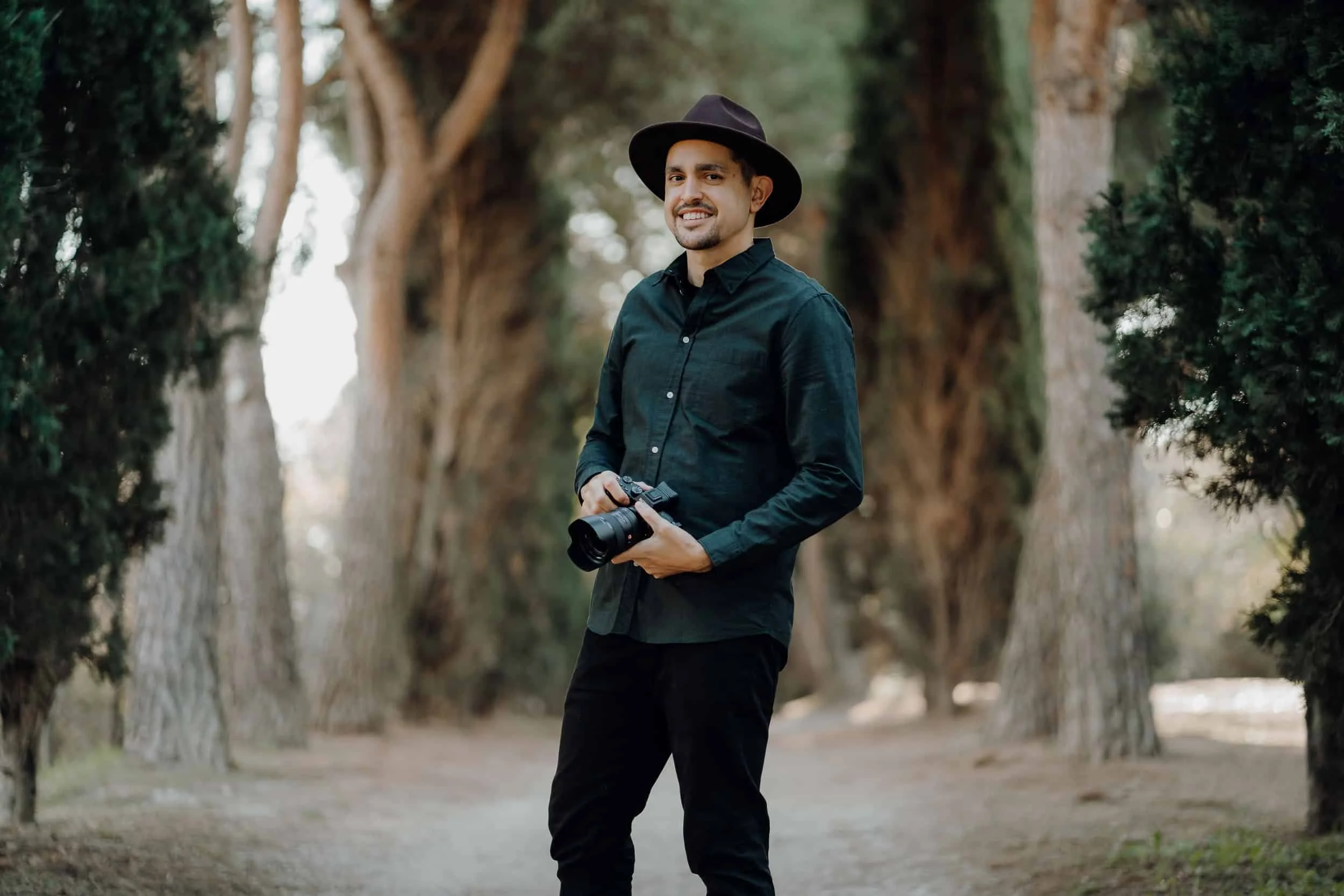 Javier standing with his camera in the woods