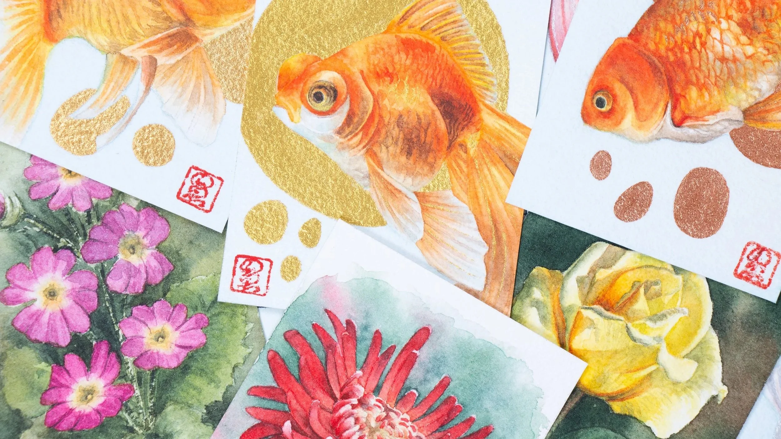 Collection of colorful artworks, including goldfish, pink and red flowers, and abstract patterns, with some featuring red stamps, on overlapping papers.