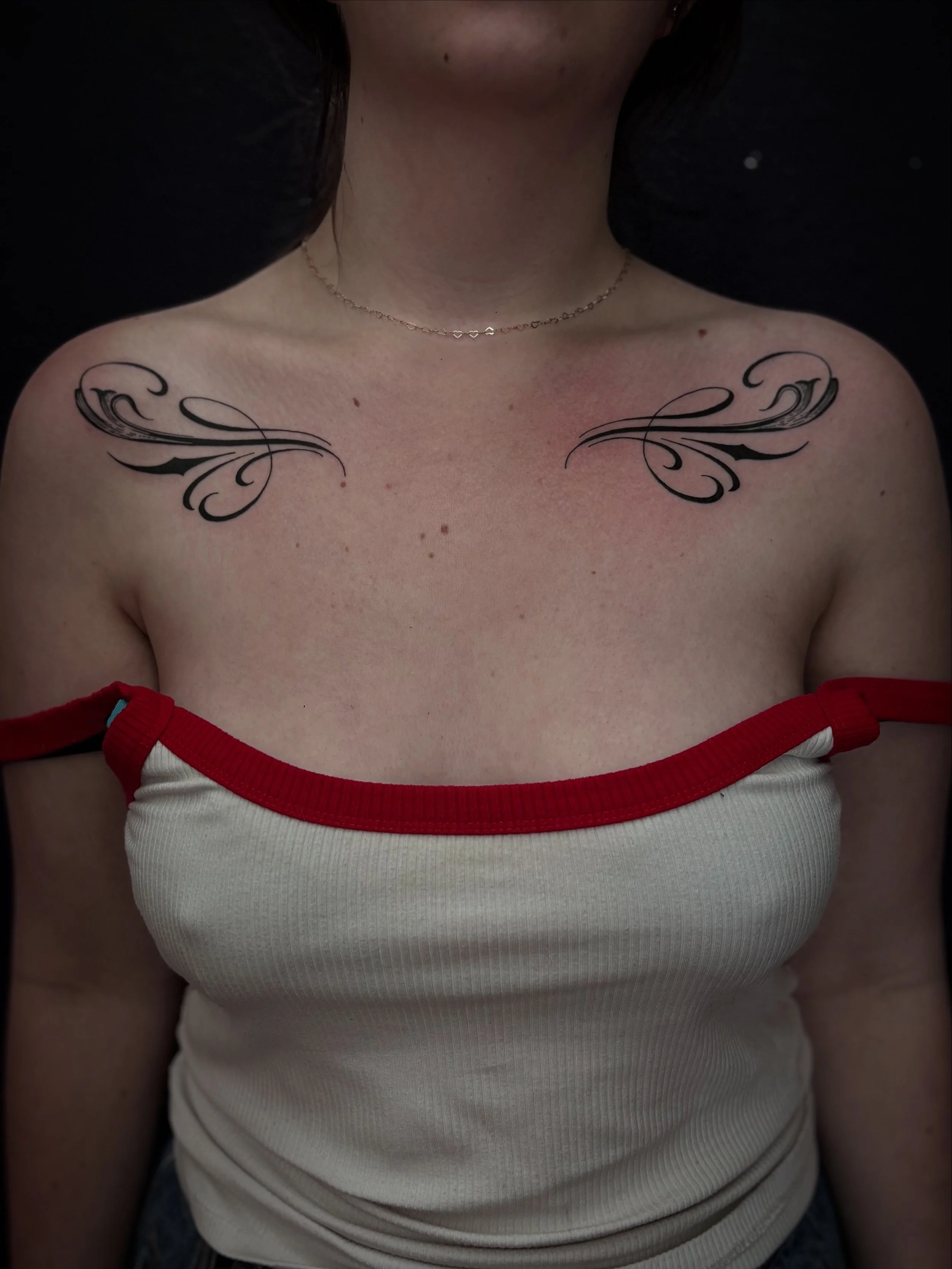 Fine-line ornamental chest tattoo