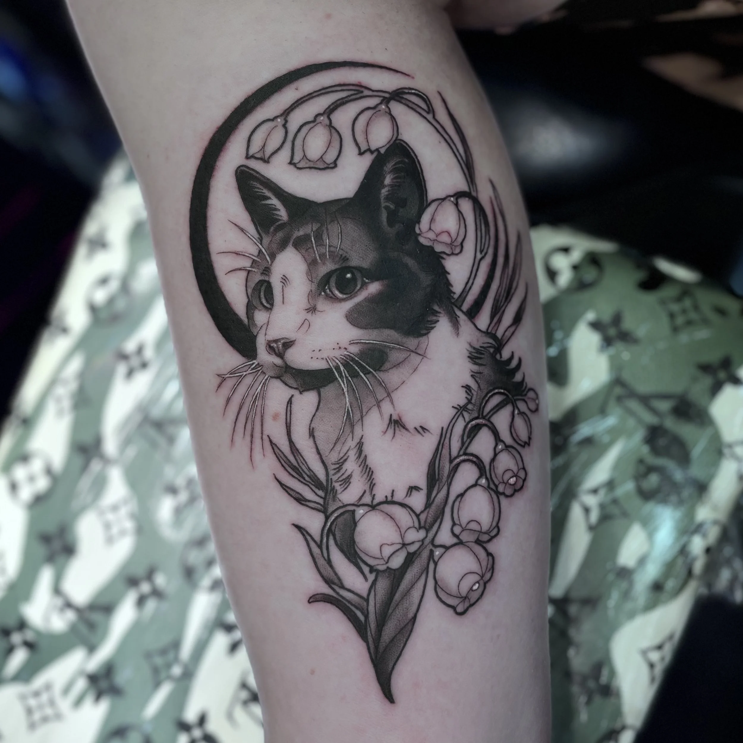 Black and gray cat and floral tattoo on arm
