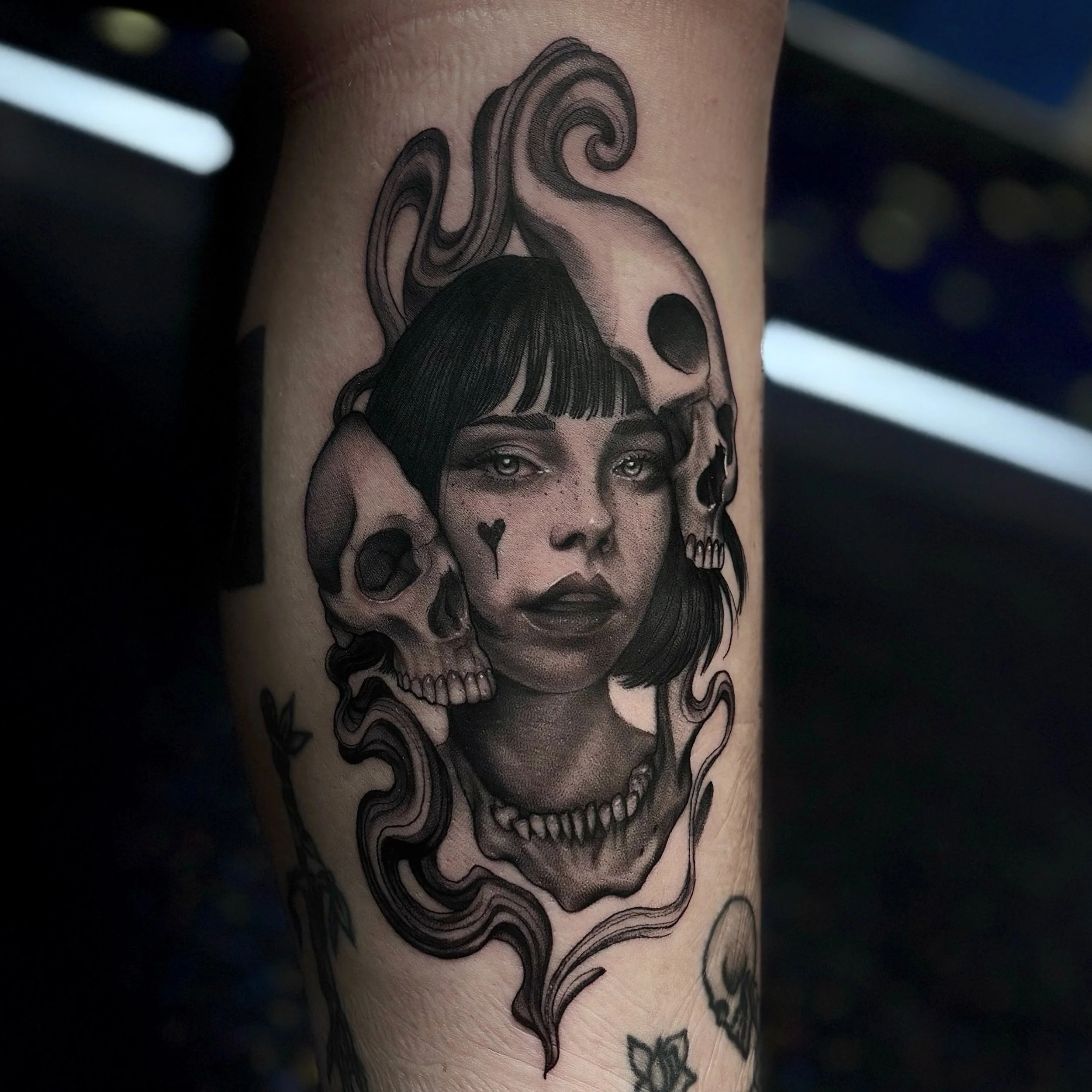 Black and gray skull portrait tattoo on forearm