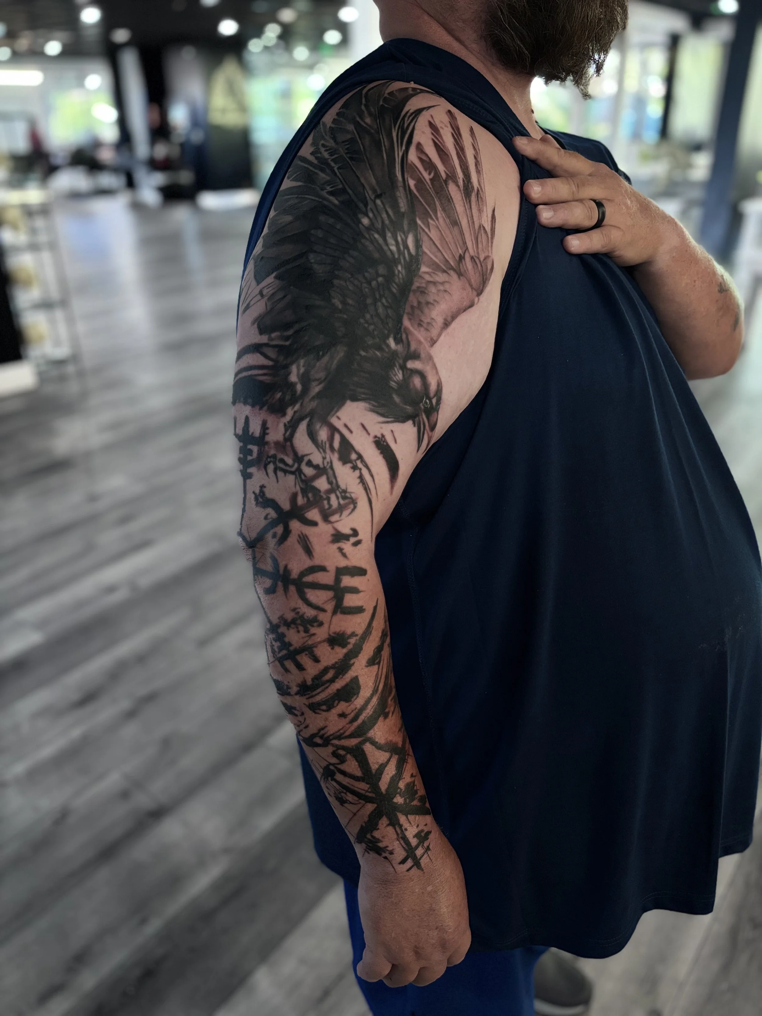 Black and gray illustrative sleeve tattoo on arm