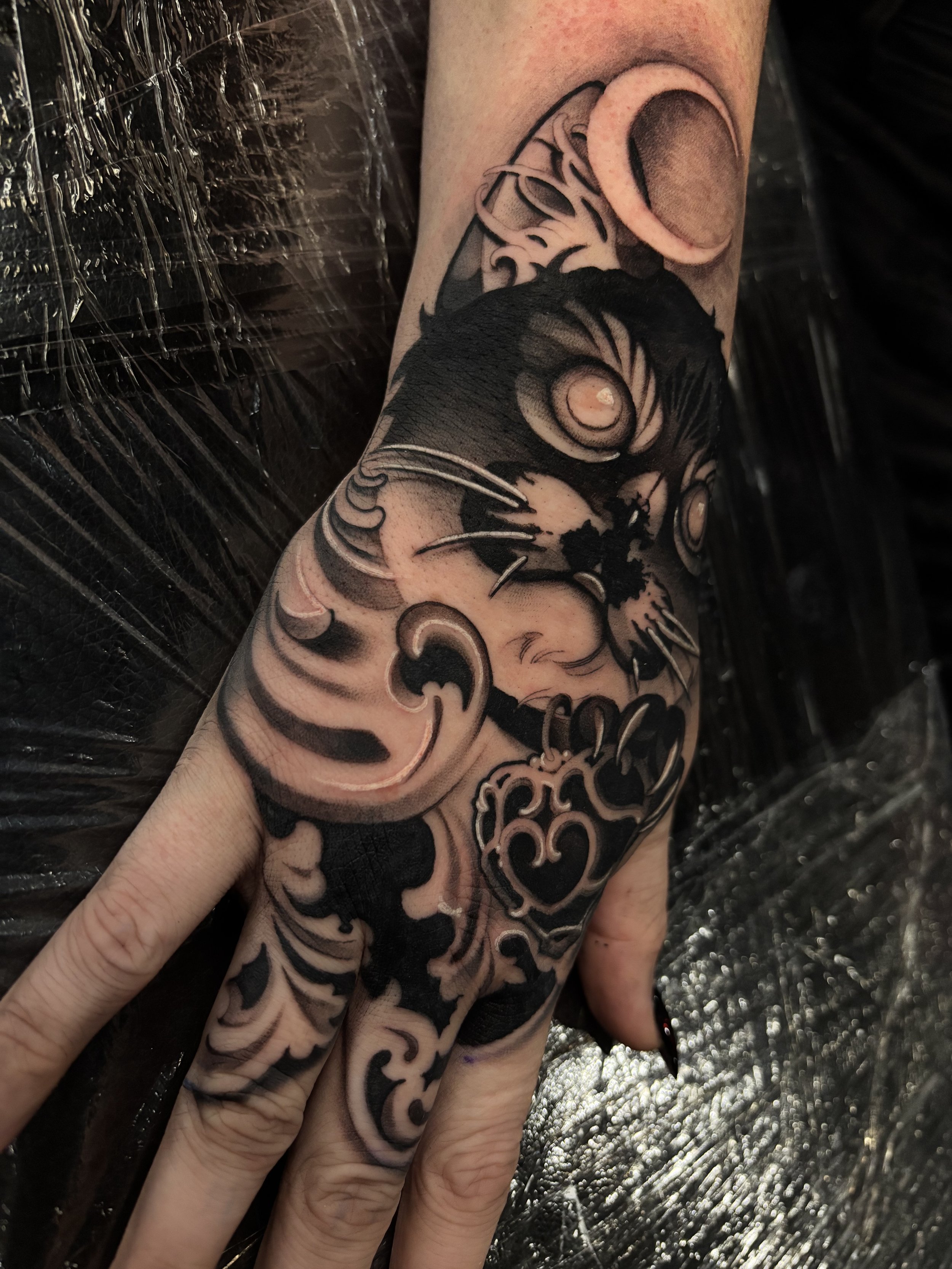 Black and gray ornamental figure tattoo on thigh