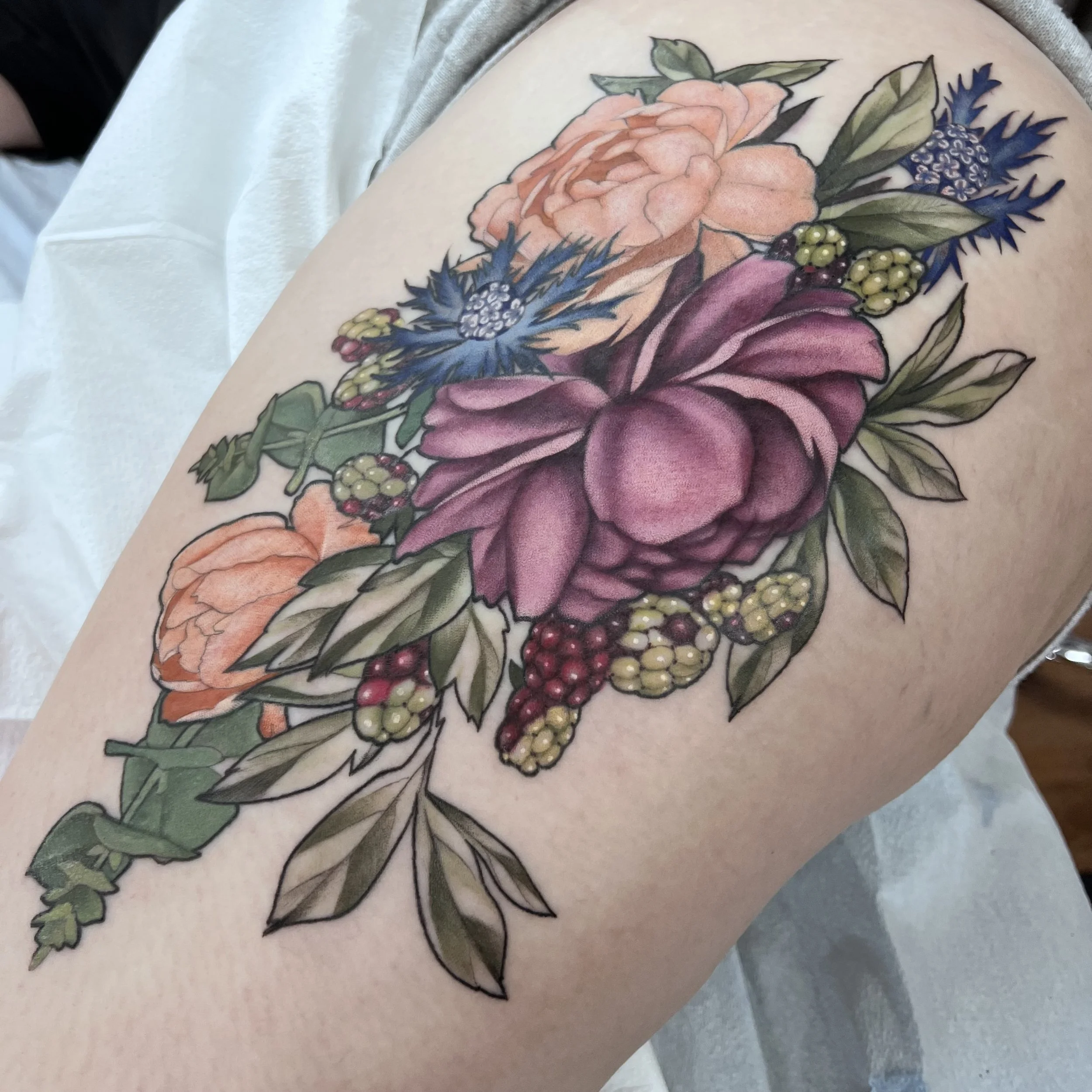 Colorful floral tattoo on thigh