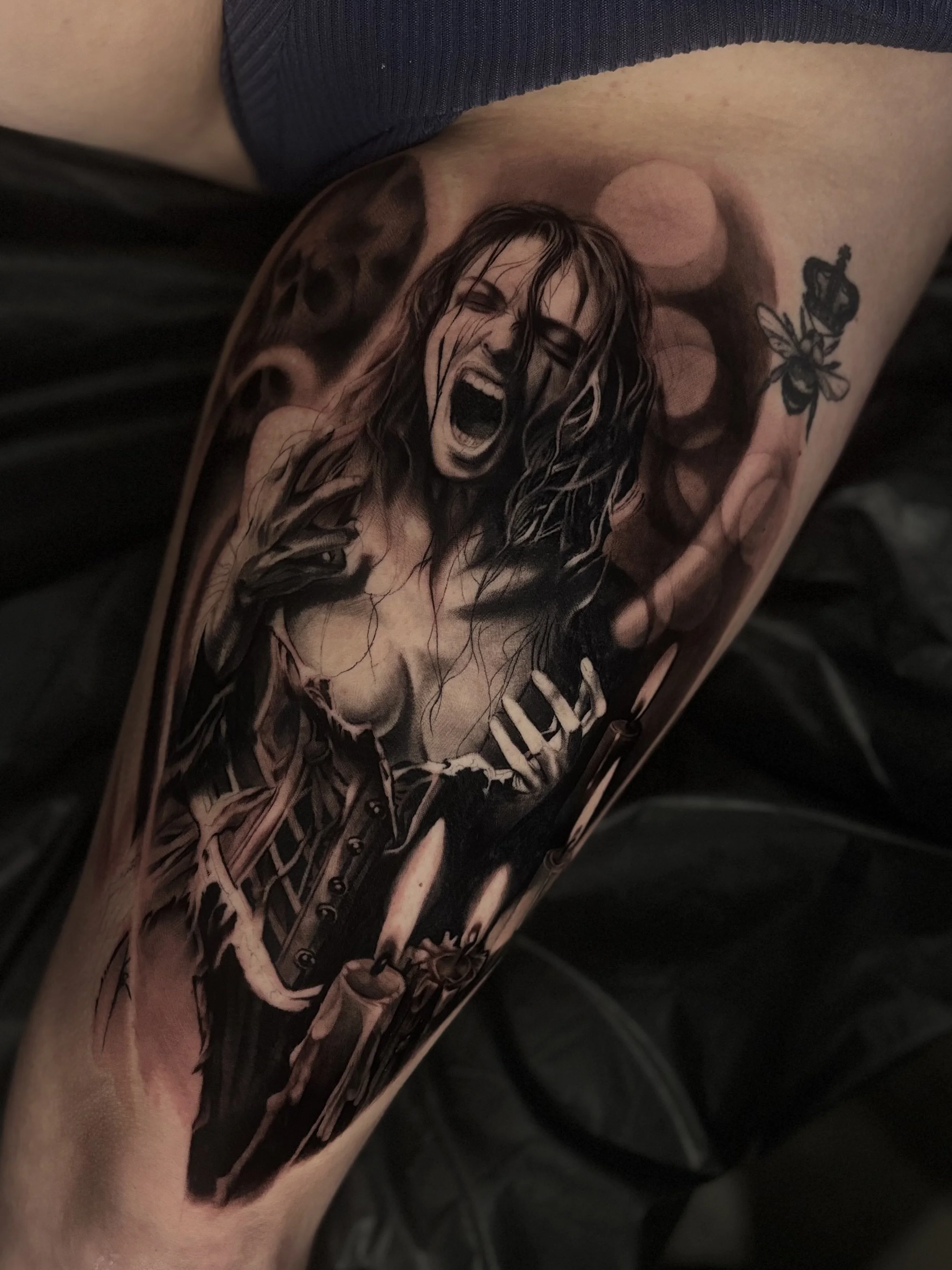 Black and gray illustrative tattoo on upper arm
