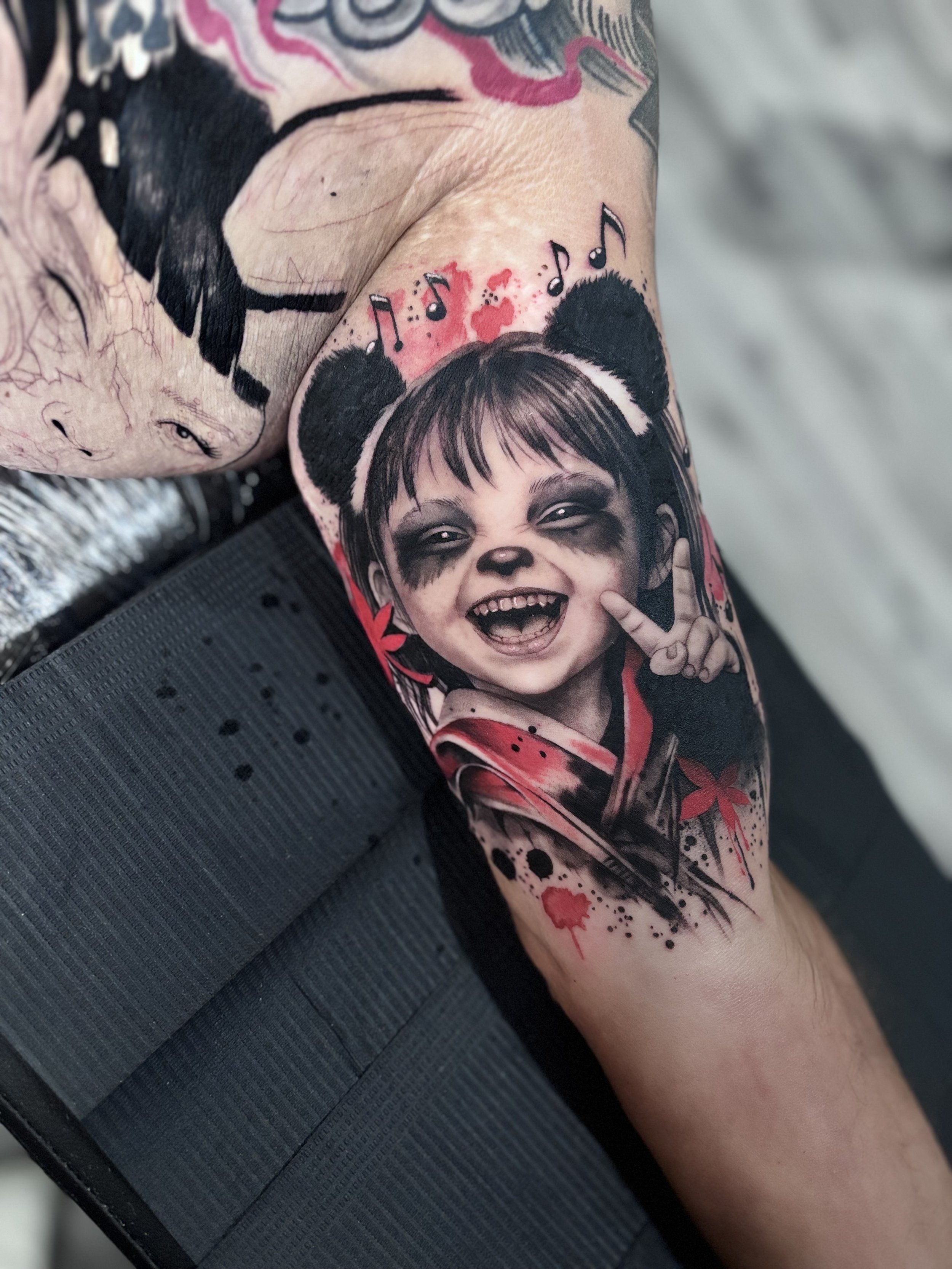 Colorful illustrative child portrait tattoo on leg
