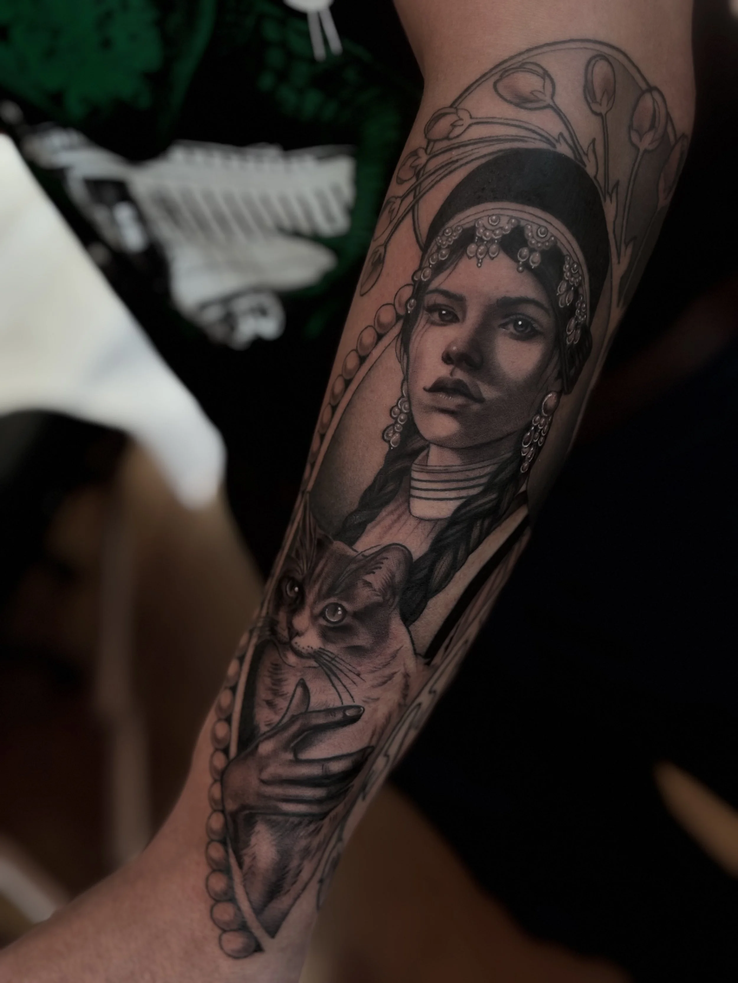 Black and gray illustrative portrait tattoo on forearm