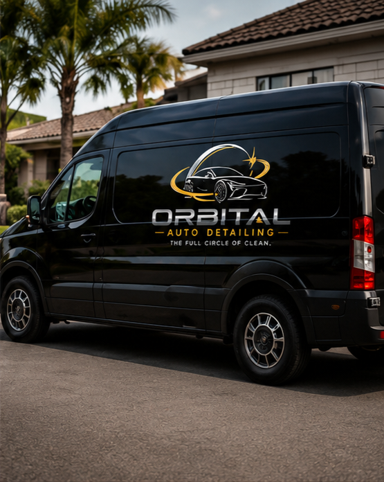 Black cargo van with logo for Orbital Auto Detailing parked on the street in front of a house with palm trees.