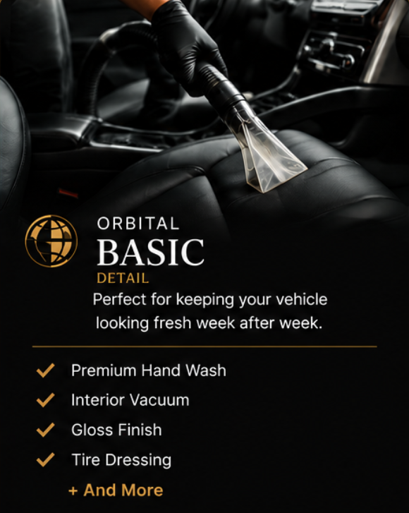 Person wearing black gloves cleaning car interior with a vacuum cleaner.