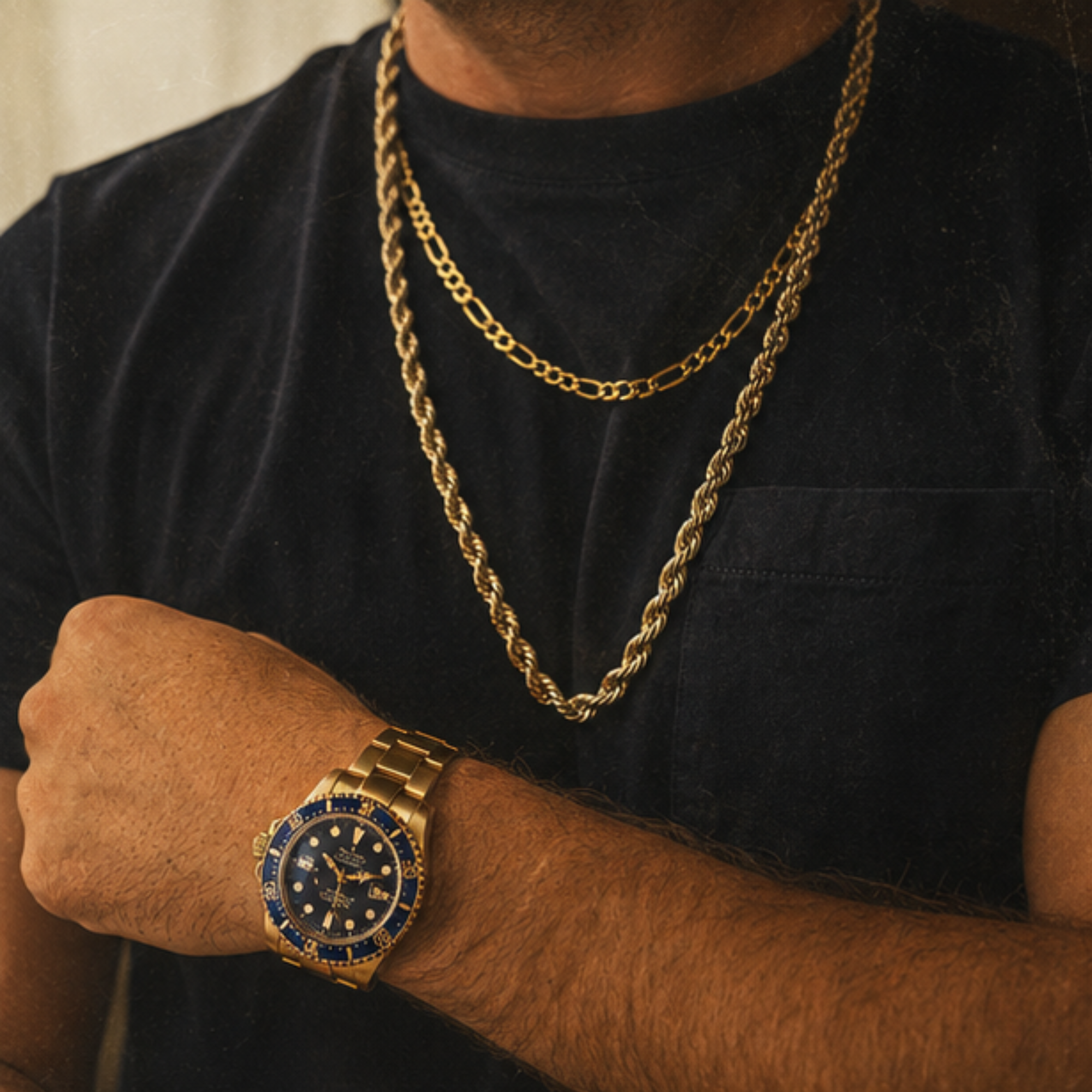 Close-up of a person's neck and shoulder area wearing a black shirt, gold jewelry including a chain necklace, a watch, and a large wristwatch with a blue face, gold band, and multiple dials.