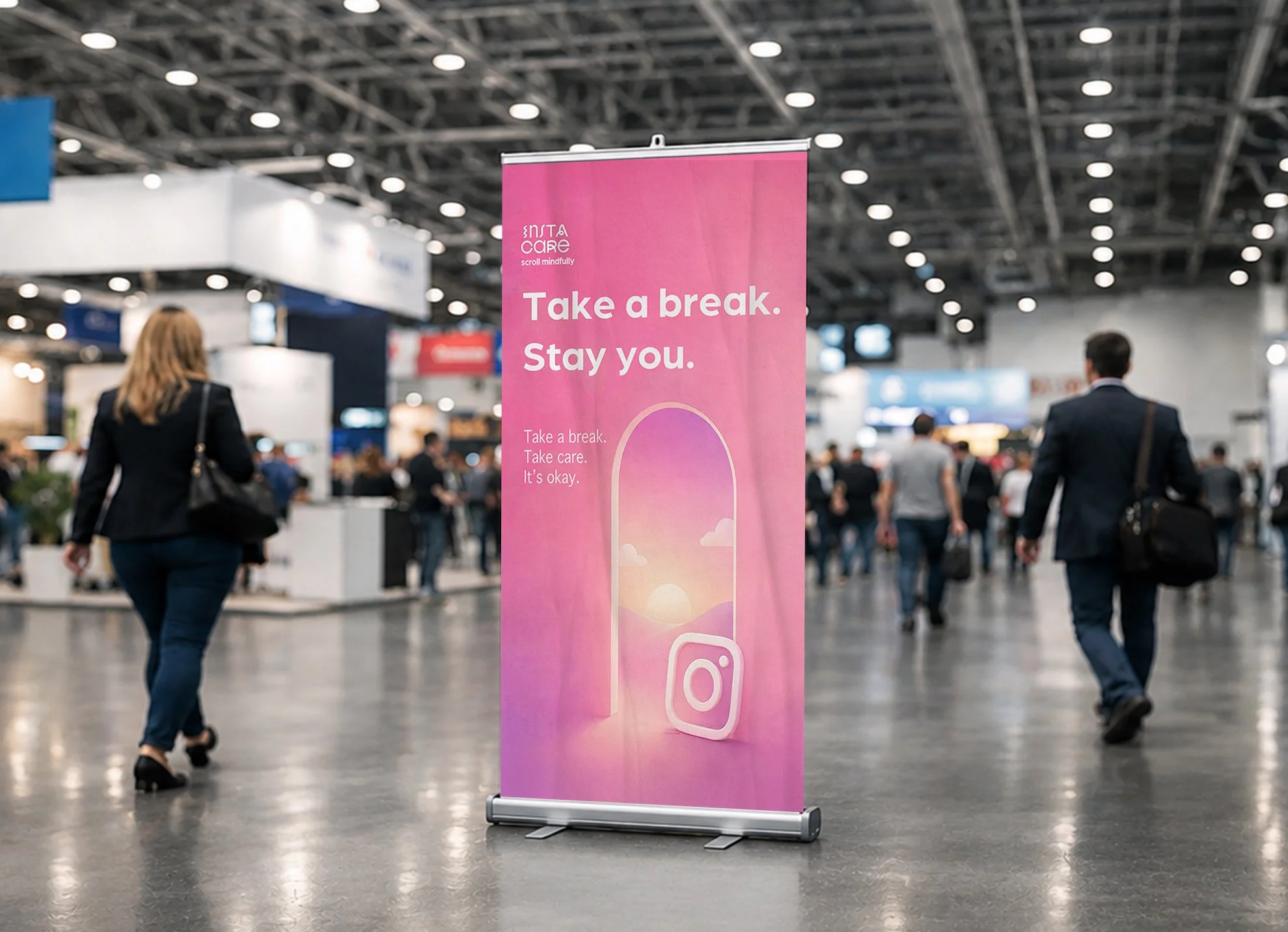 Pink vertical banner in an indoor convention center with the message: "Take a break. Stay you. Take a break. Take care. It's okay." showing a narrow doorway with relaxing clouds next to an instagram logo.  People are walking around in the background.