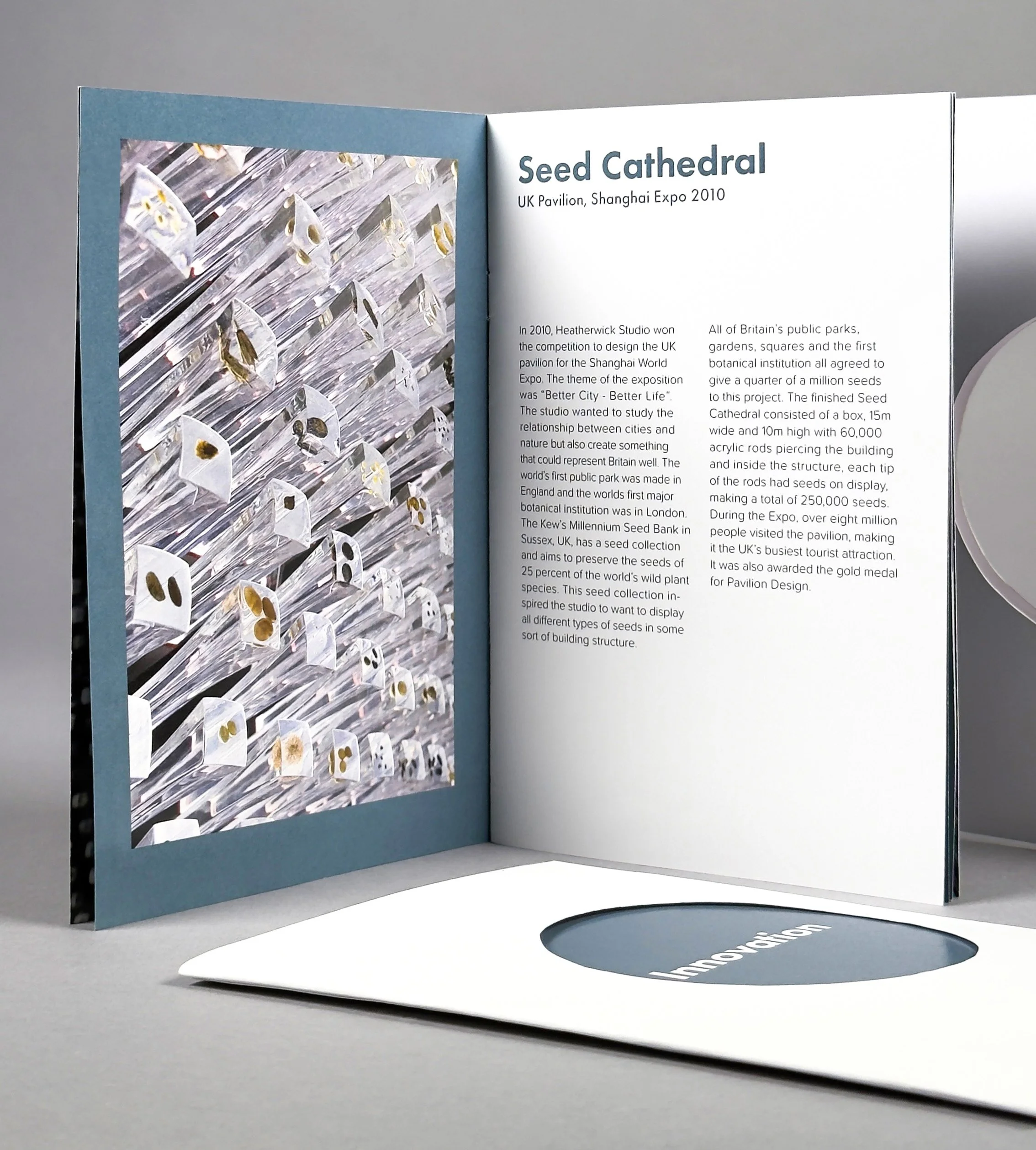Open booklet or brochure displaying an exhibition on the Seed Cathedral, with an image on the left page showing glass rods embedded with seeds, and text on the right discussing the Seed Cathedral at the Shanghai Expo 2010.
