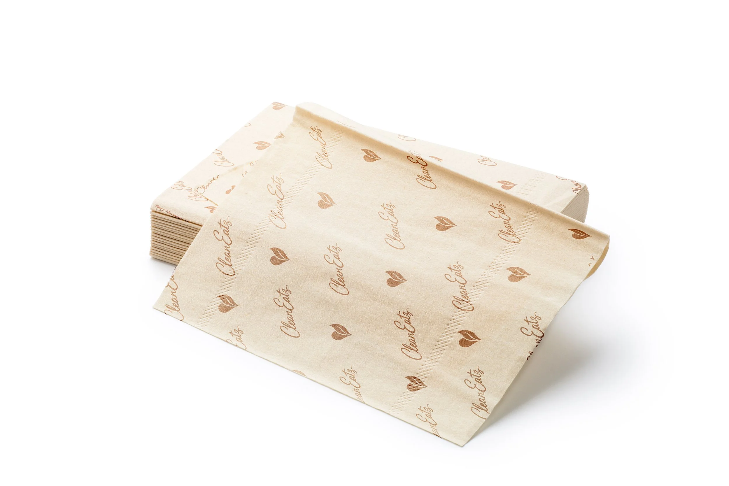 A stack of beige napkins with brown cursive text and small hearts, reading "CleanEatz" placed on a plain white background.