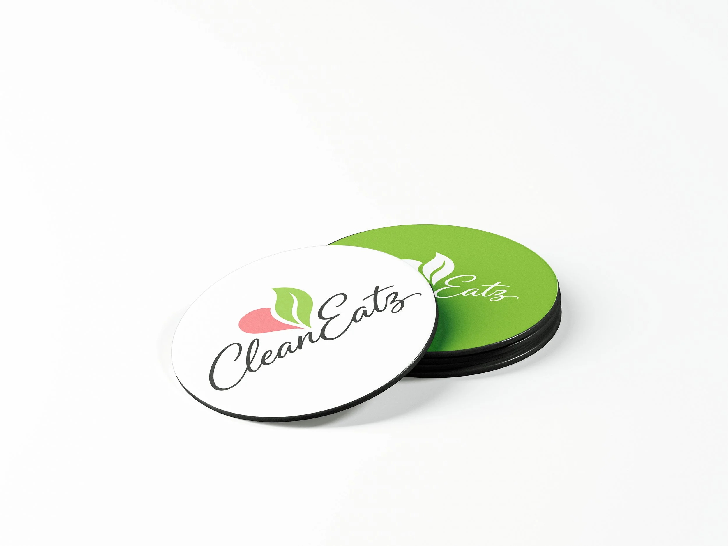 Close-up of cup coasters with a white and green label that reads 'CleanEatz' with a pink and green logo, partially visible.