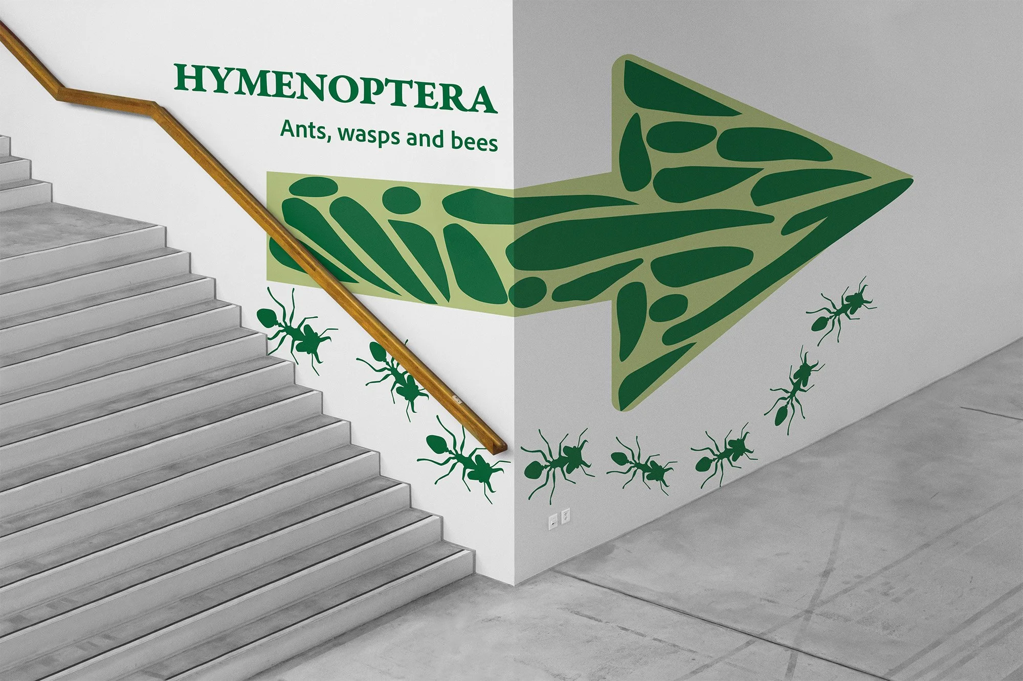 Staircase with a mural of green ants, wasps, and bees on the wall near the stairs, including a large green arrow filled with geometric patterns.