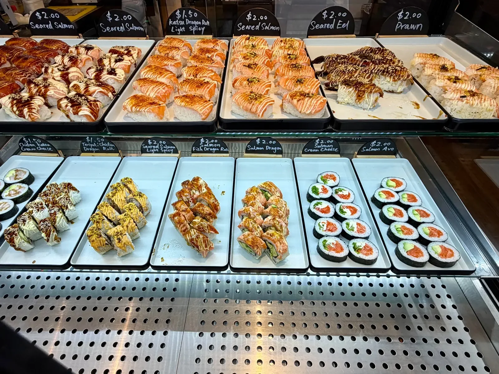 Fresh salmon sushi and assorted sushi rolls displayed at One Sushi Wigram.