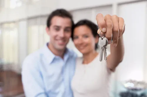 New homeowners receiving keys after completing a property purchase
