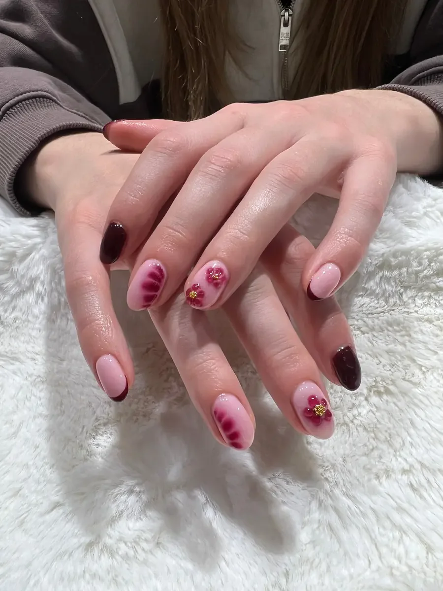 Pink and burgundy manicure with floral nail art at Petals Nail Salon Wigram